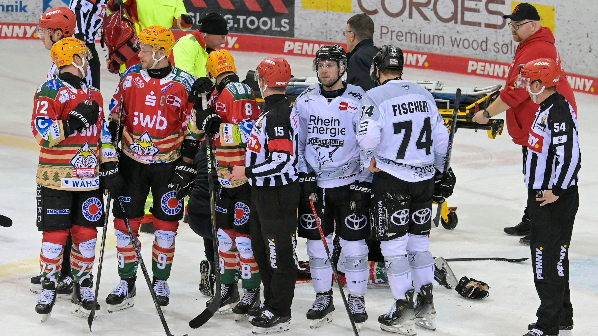 Kölner (weiß) und Bremerhavener Spieler bilden nach der Verletzung von Christian Wejse einen Sichtschutz.
