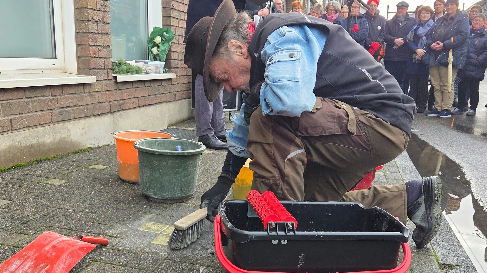 Gunter Demnig, Initiaor des Stolpersteine-Projekts in Deutschland, setzt die drei ersten Stolpersteine von Spich in den Asphalt ein.