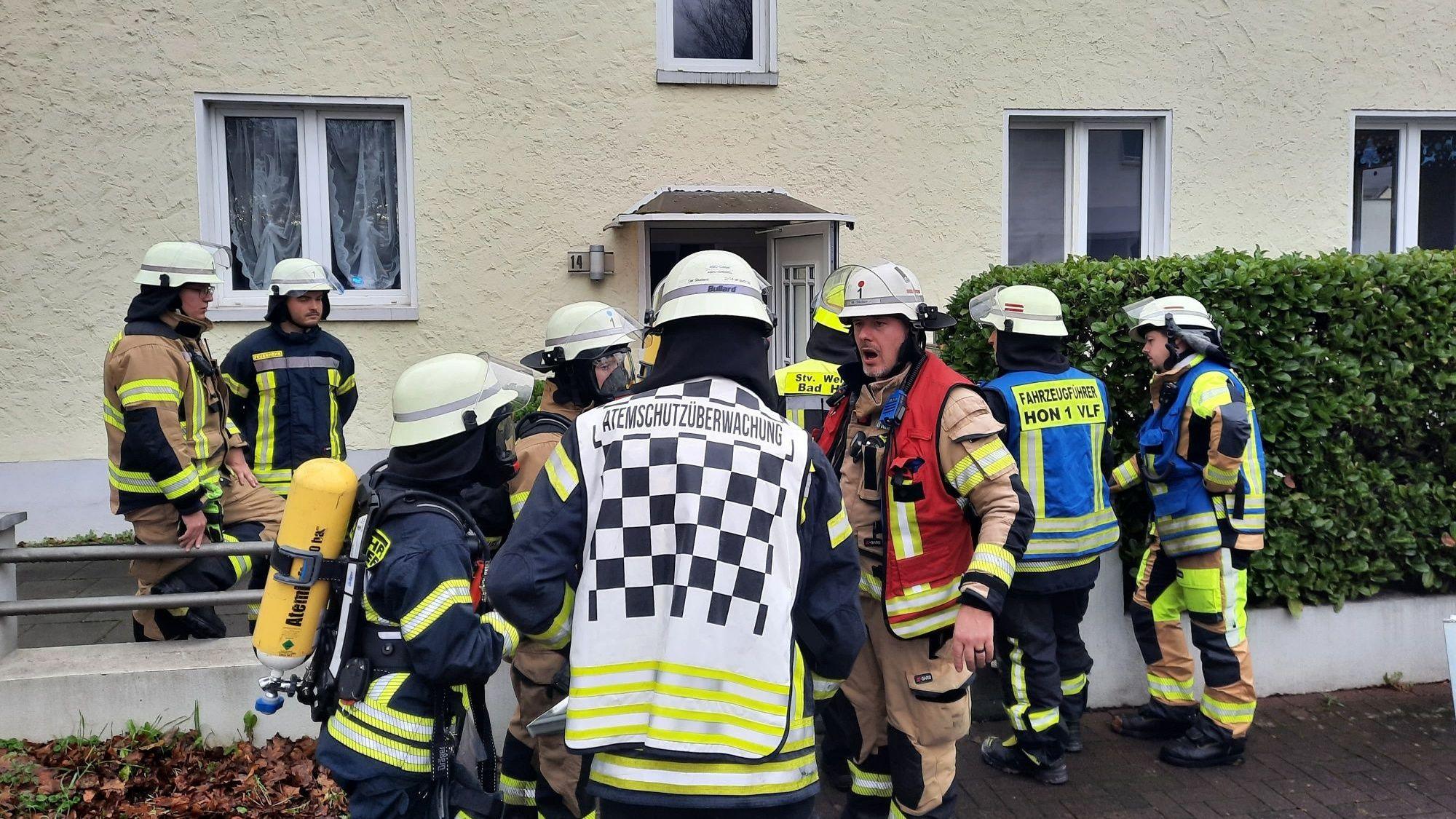 Feuerwehrleute vor einem Mehrfamilienhaus.