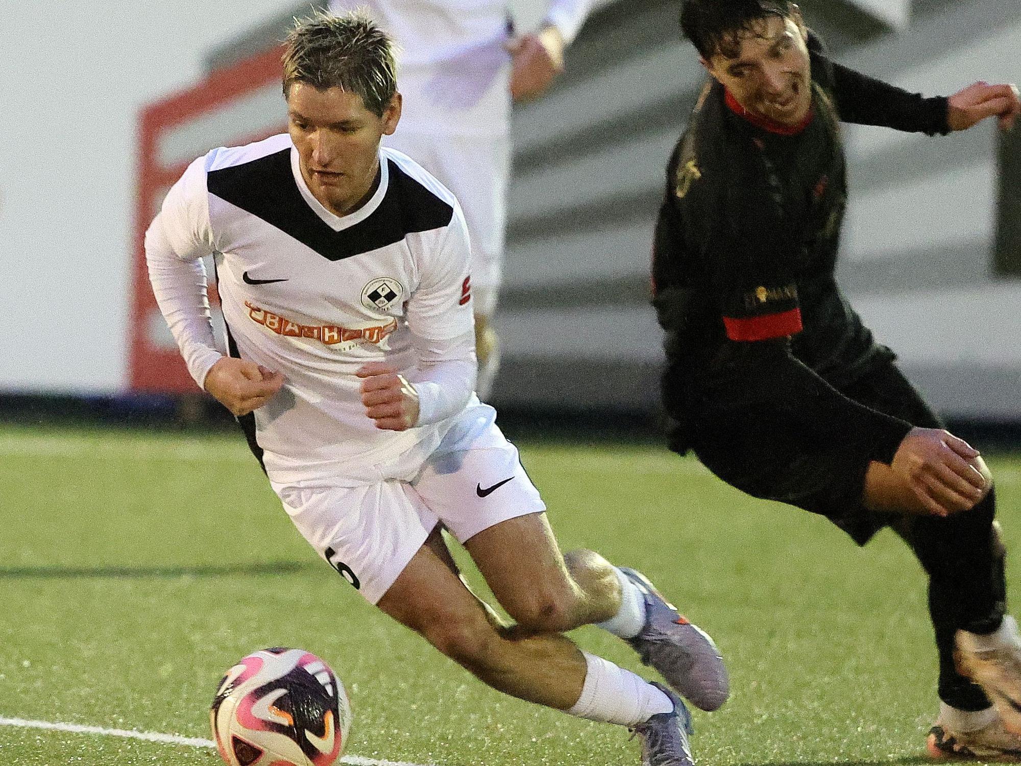 Auf dem Foto ist ein Spieler der SpVg Frechen 20, der seinen Gegenspieler mit dem Ball am Fuß elegant umkurvt.