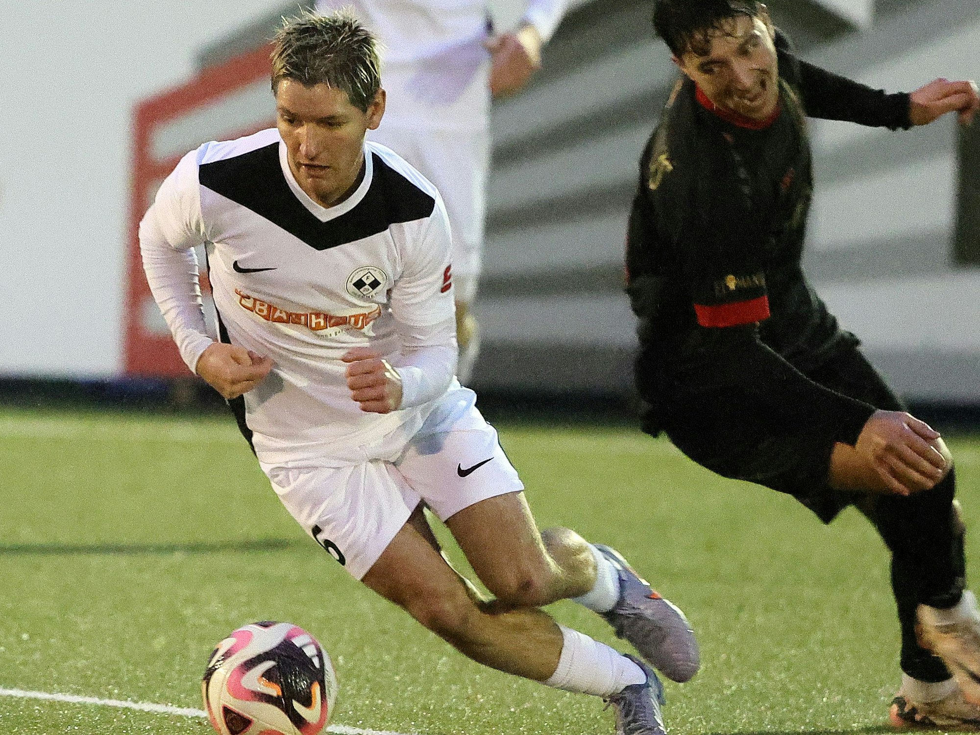 Auf dem Foto ist ein Spieler der SpVg Frechen 20, der seinen Gegenspieler mit dem Ball am Fuß elegant umkurvt.