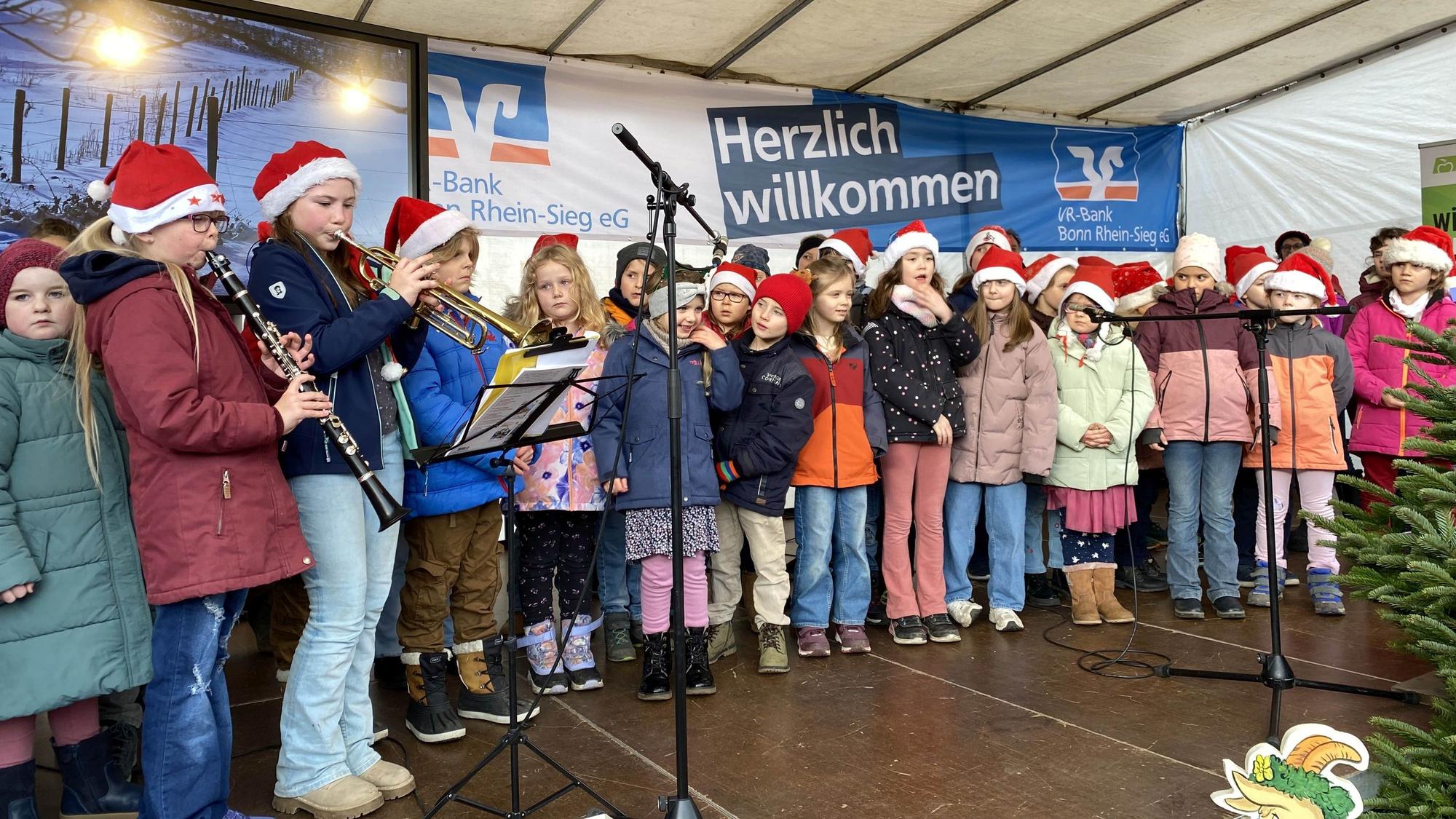 Kinder der Katholischen Grundschule Merl singen auf der Bühne.