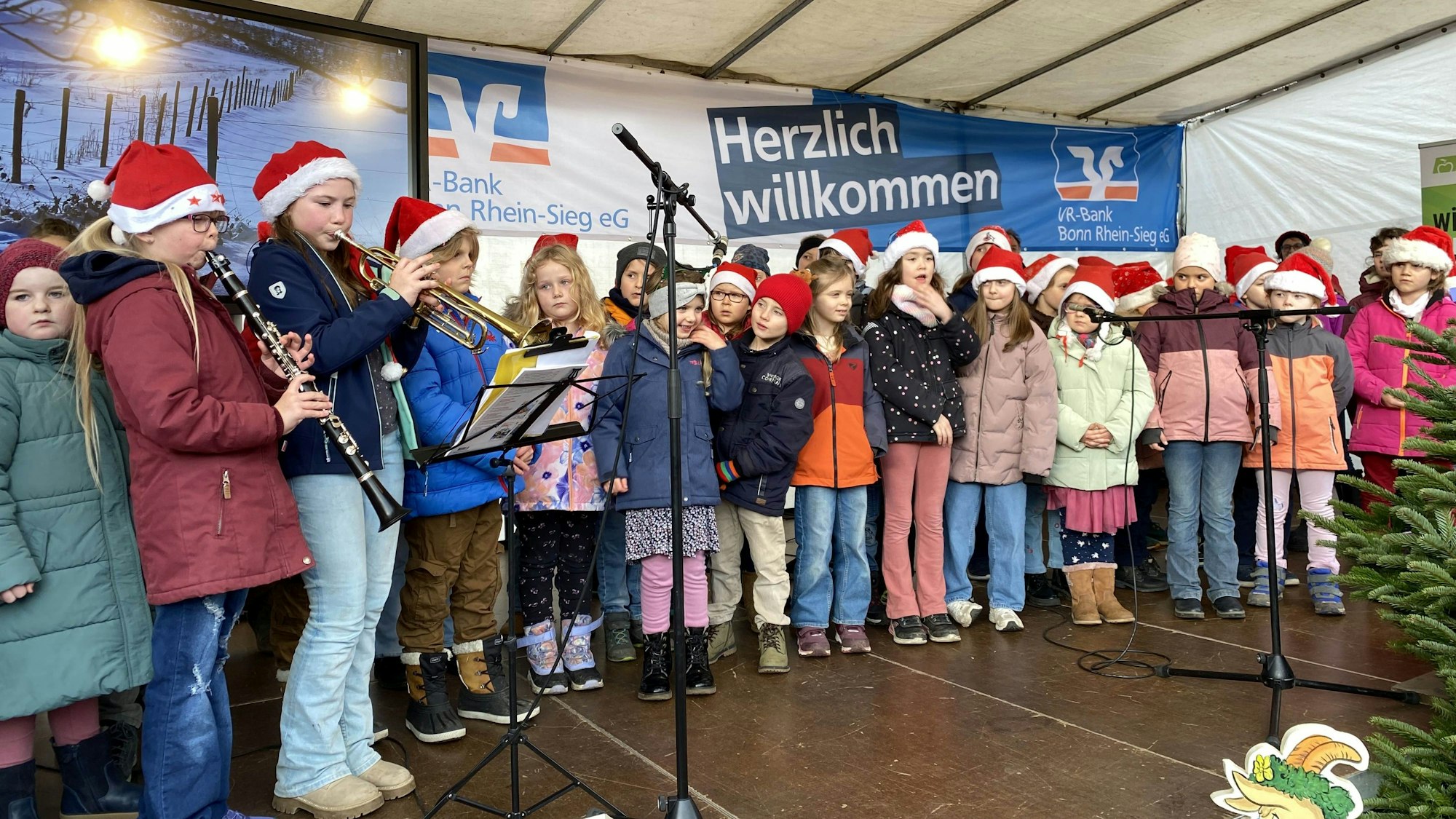 Kinder der Katholischen Grundschule Merl singen auf der Bühne.