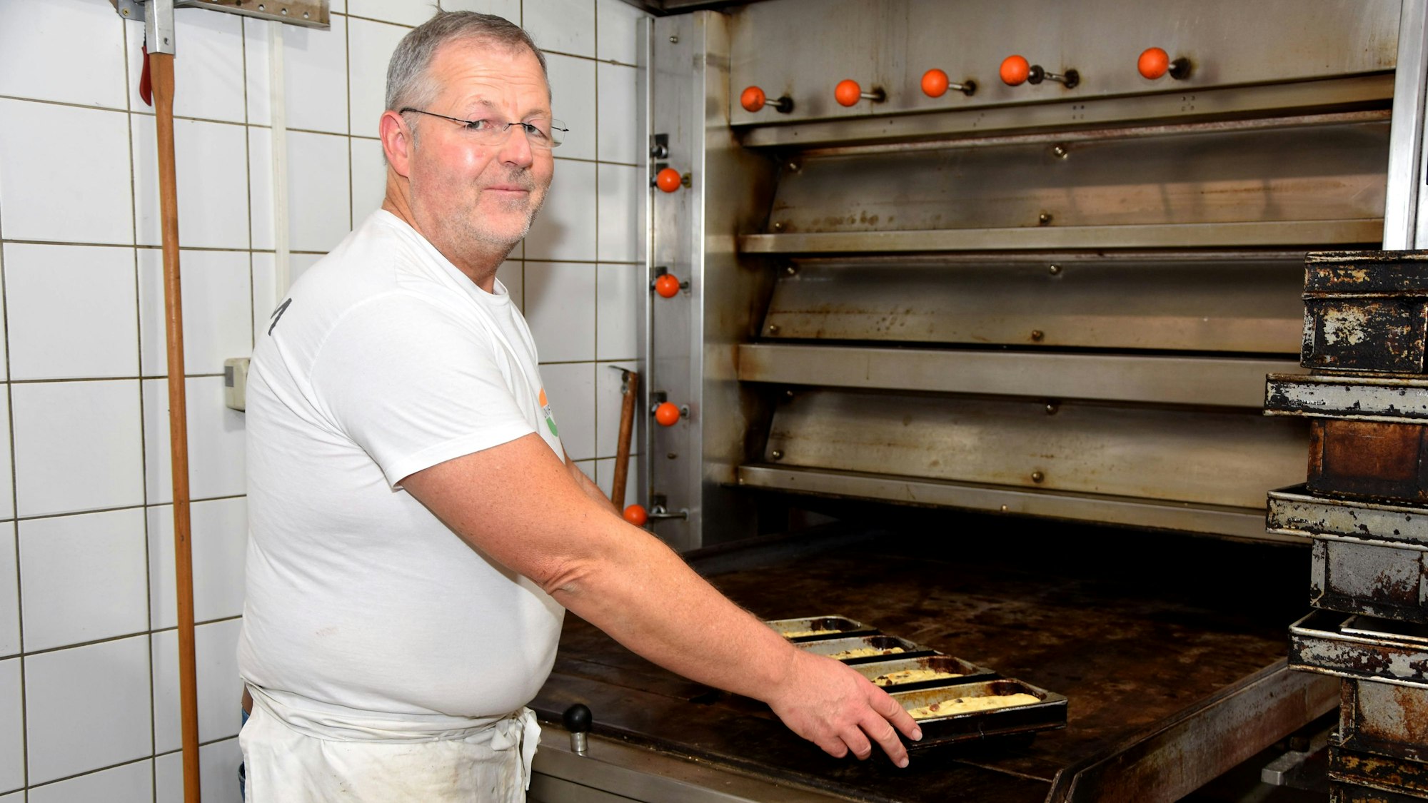 Das Foto zeigt einen Bäcker am Ofen.