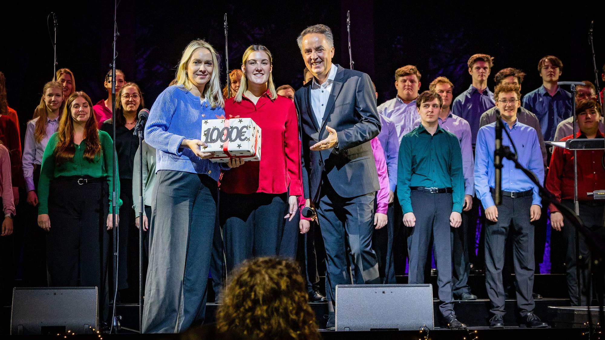 1000 Euro für die Altenhilfe: Chorleiter Michael Kokott überreicht Julia Heinen (links) symbolisch ein Geschenk.