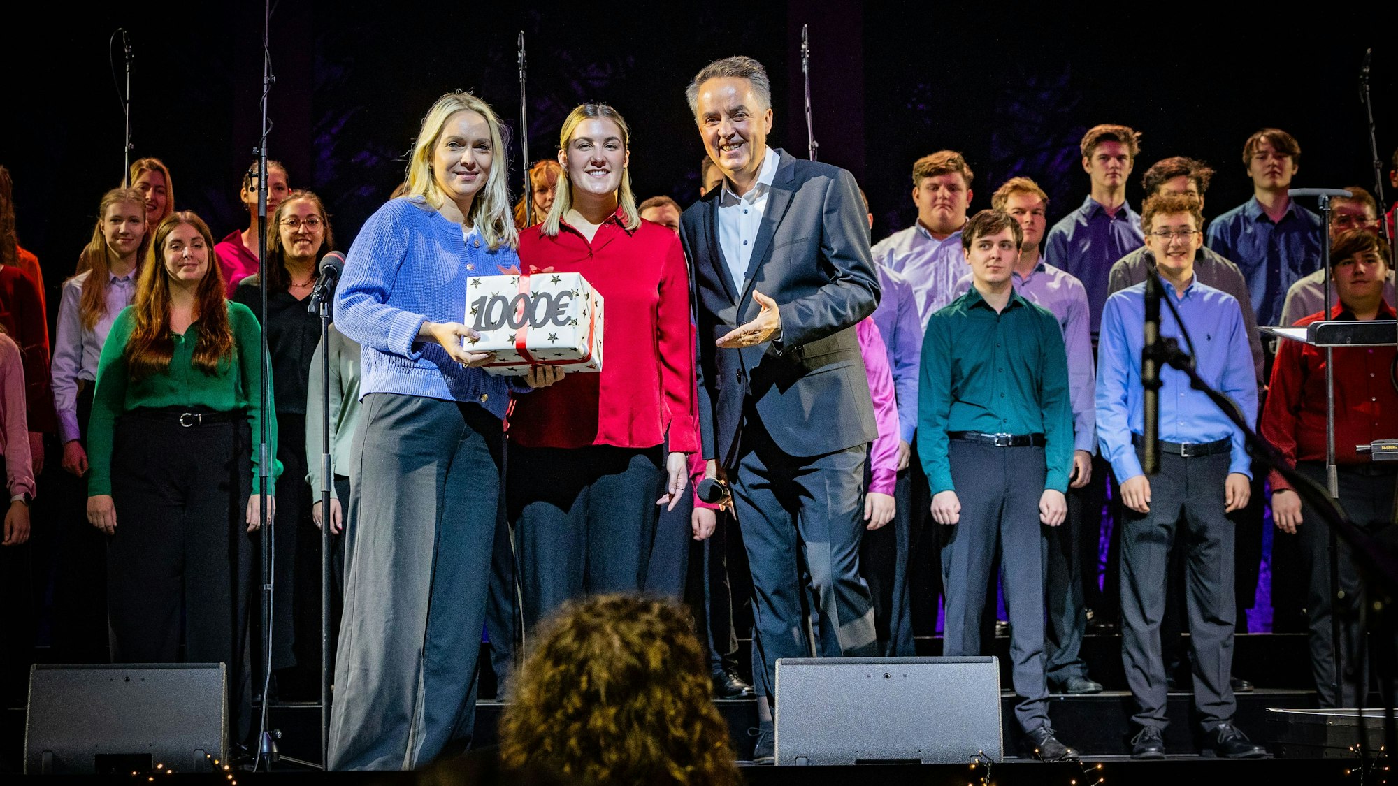 1000 Euro für die Altenhilfe: Chorleiter Michael Kokott überreicht Julia Heinen (links) symbolisch ein Geschenk.