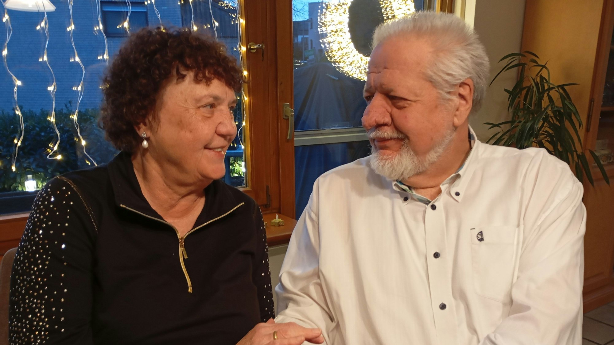 Eine Frau und ein Mann schauen sich an, beide lächeln.