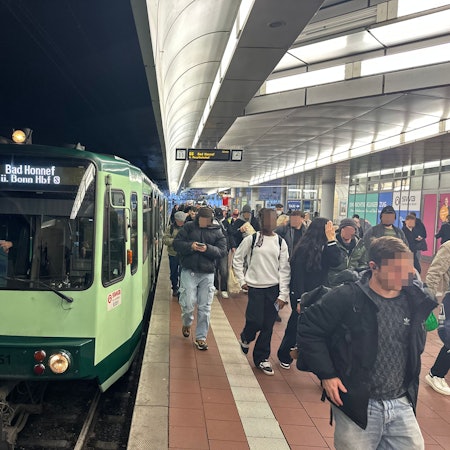 Eine Bahn der Linie 66 steht am Gleis in Siegburg. Menschen steigen aus und ein.