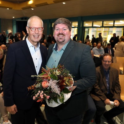 Dr. Hermann-Josef Tebroke (l.) Stellung. Sein Nachfolger wurde Maurice Winter (r.) stehen mit einem Blumenstrauß nebeneinander beim Kreisparteitag der CDU Rhein-Berg.
