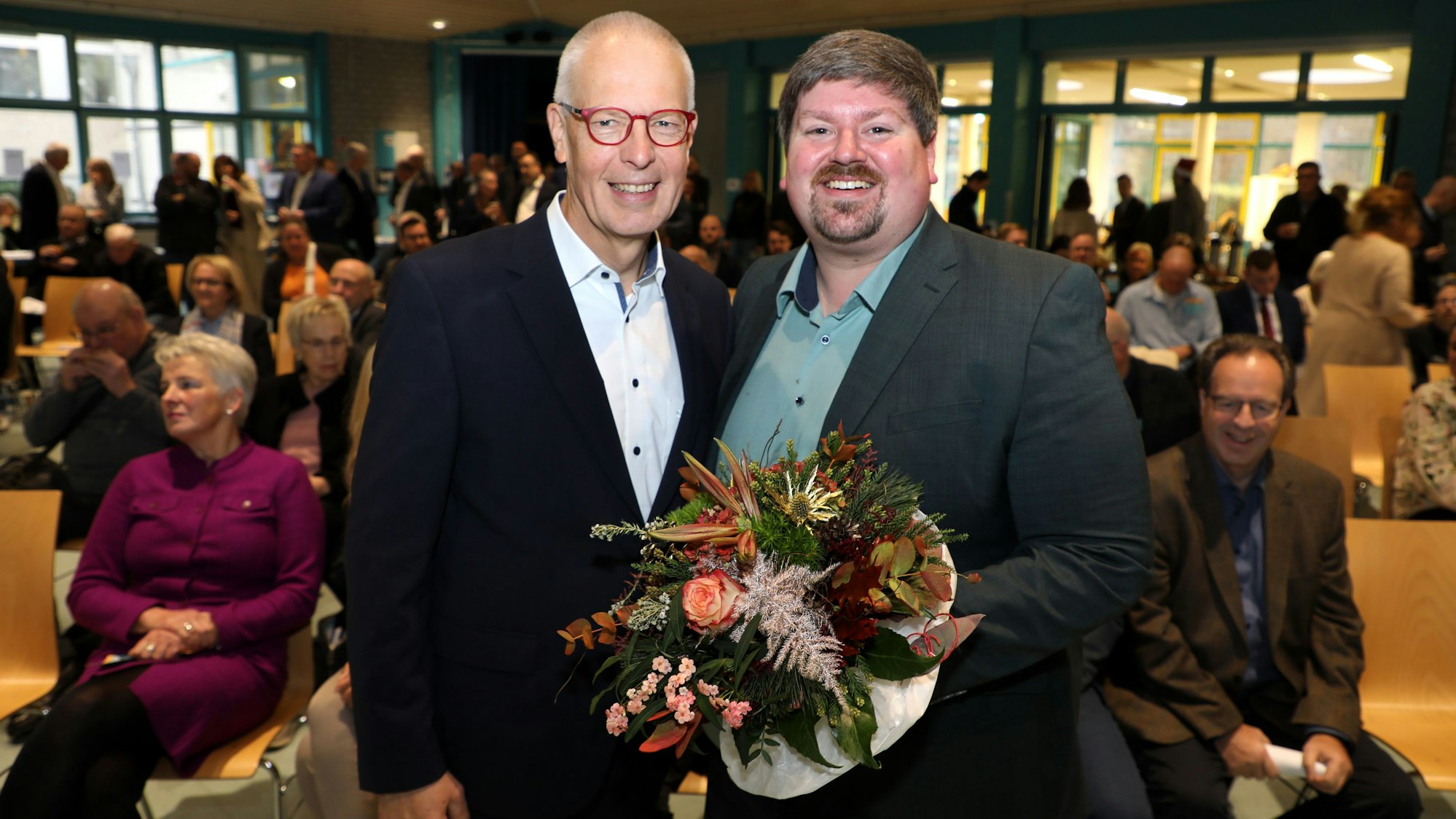 Dr. Hermann-Josef Tebroke (l.) Stellung. Sein Nachfolger wurde Maurice Winter (r.) stehen mit einem Blumenstrauß nebeneinander beim Kreisparteitag der CDU Rhein-Berg.