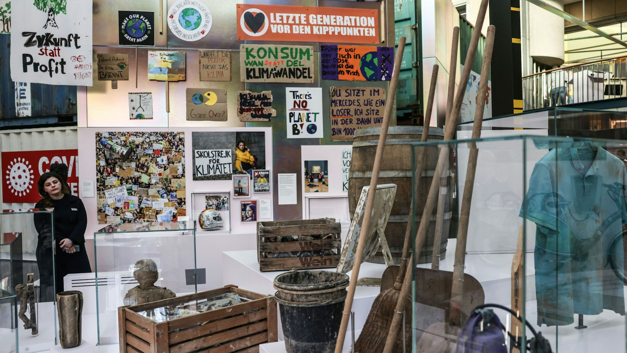 Bonn: Relikte der Flutkatastrophe im Ahrtal (vorne) und Plakate von Klimaktivisten (hinten) sind im Haus der Geschichte zu sehen.