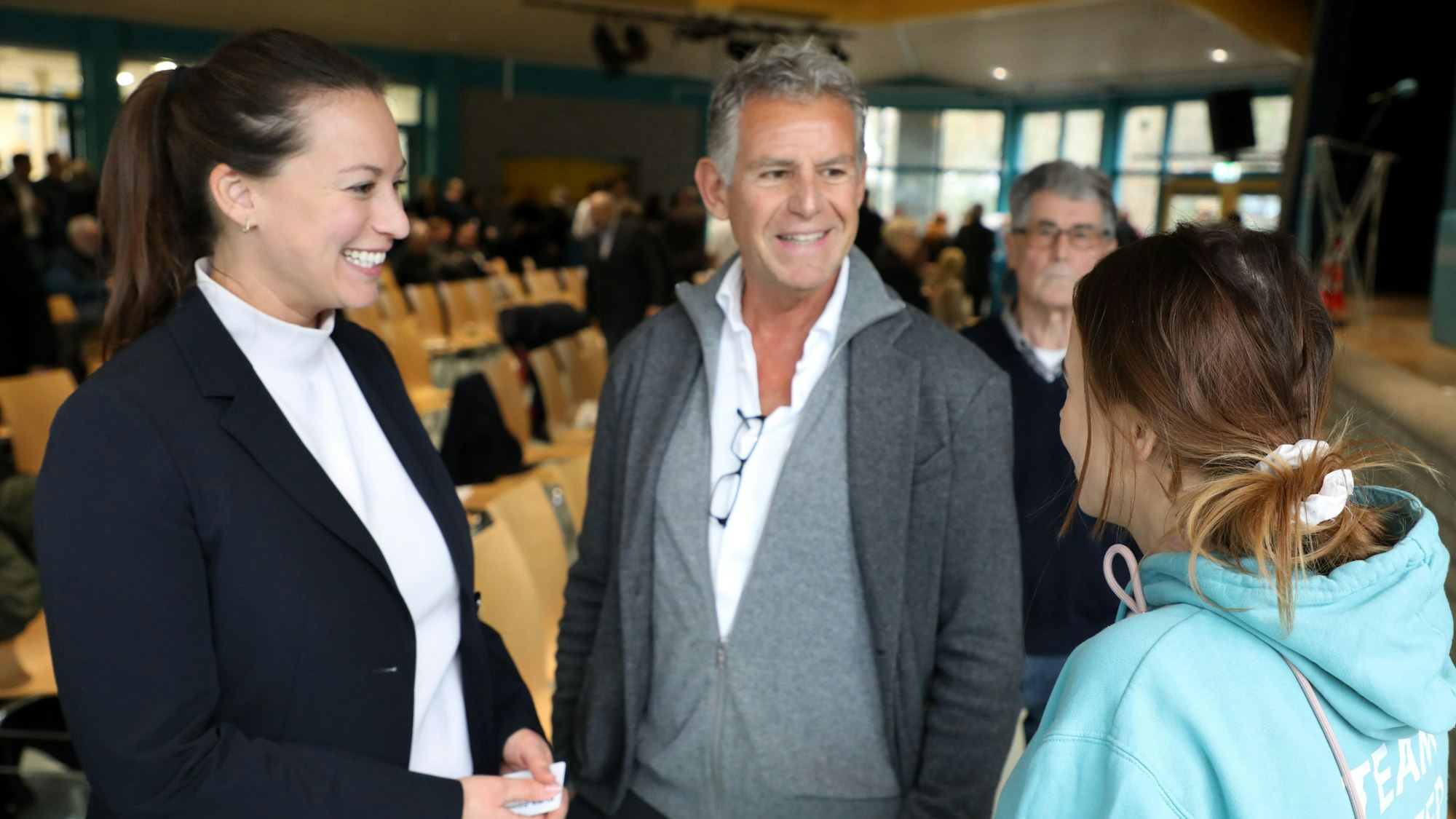 Caroline Bosbach steht mit Horst Becker, einem langjährigen Freund ihres Vaters Wolfgang Bosbach, und einer Mitarbeiterin von Maurice Winter aus Leichlingen beim Kreisparteitag der CDU Rhein-Berg und spricht.