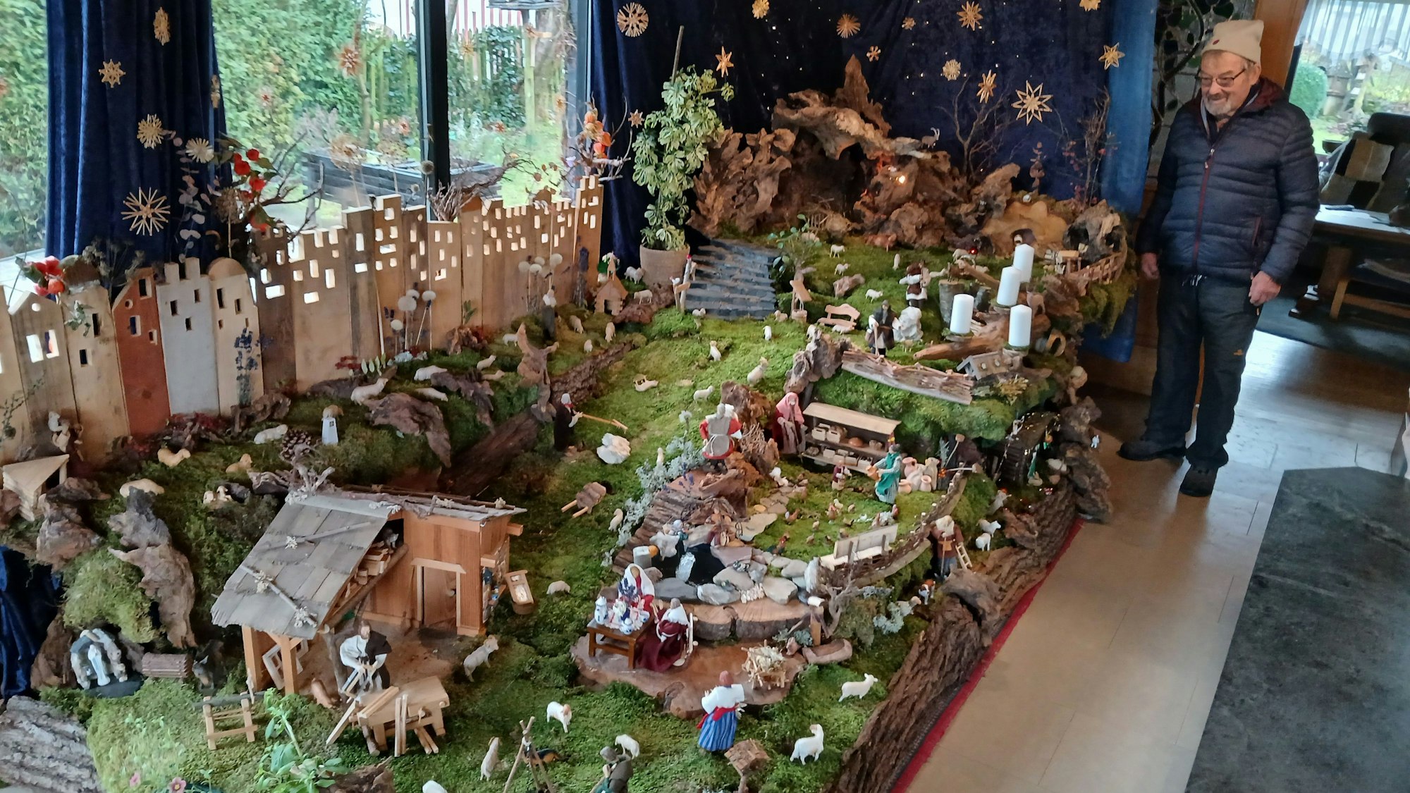 Hans Murk steht neben seiner Zehn-Quadratmeter-Krippe im heimischen Wohnzimmer.