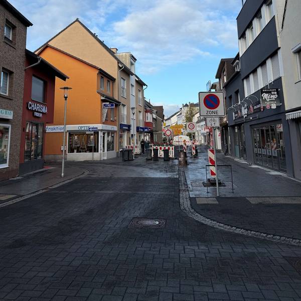 Die Straße im Vordergrund ist wieder befahrbar, dahinter ist eine Baustellenabsperrung.