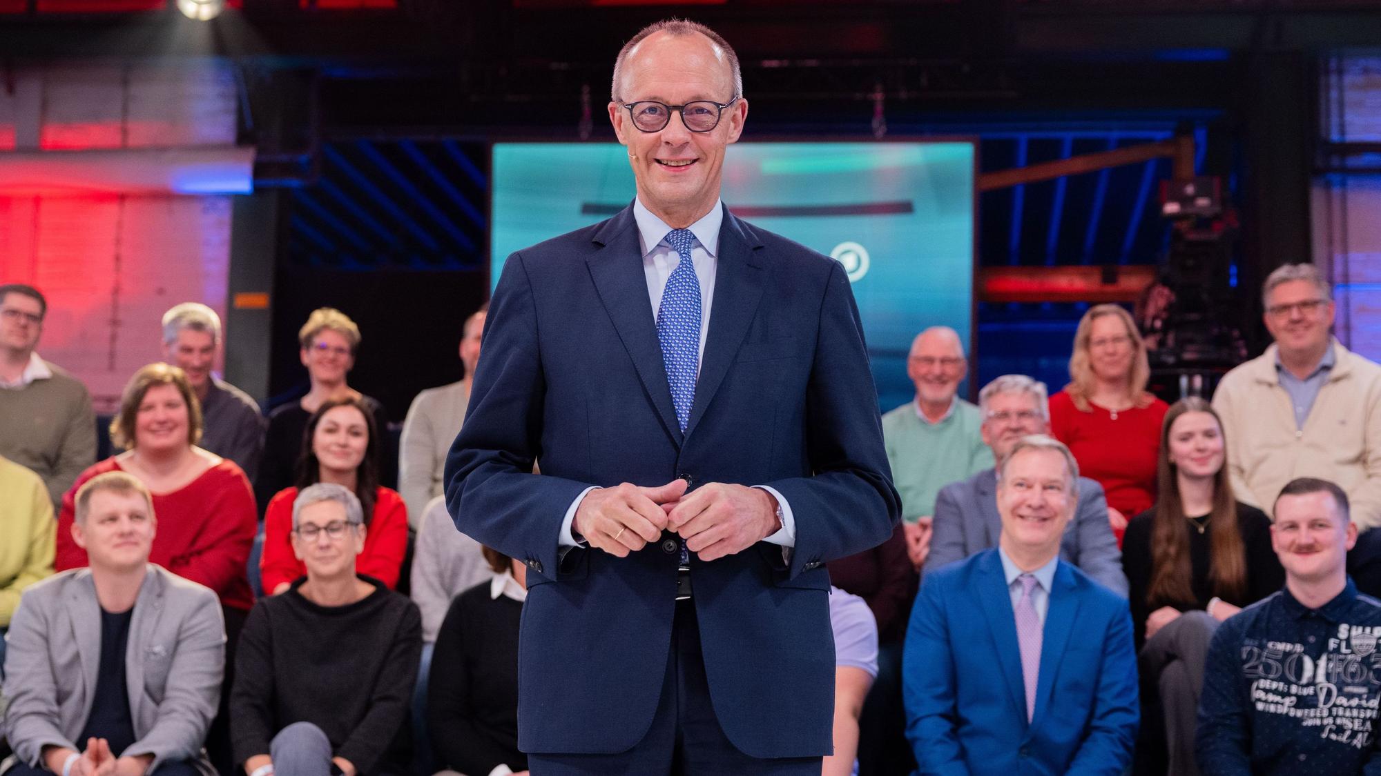 Friedrich Merz in der ARD-Sendung Arena, im Hintergrund Notfallsanitäter Hartmut Kreutz (vorderste Reihe, ganz links).