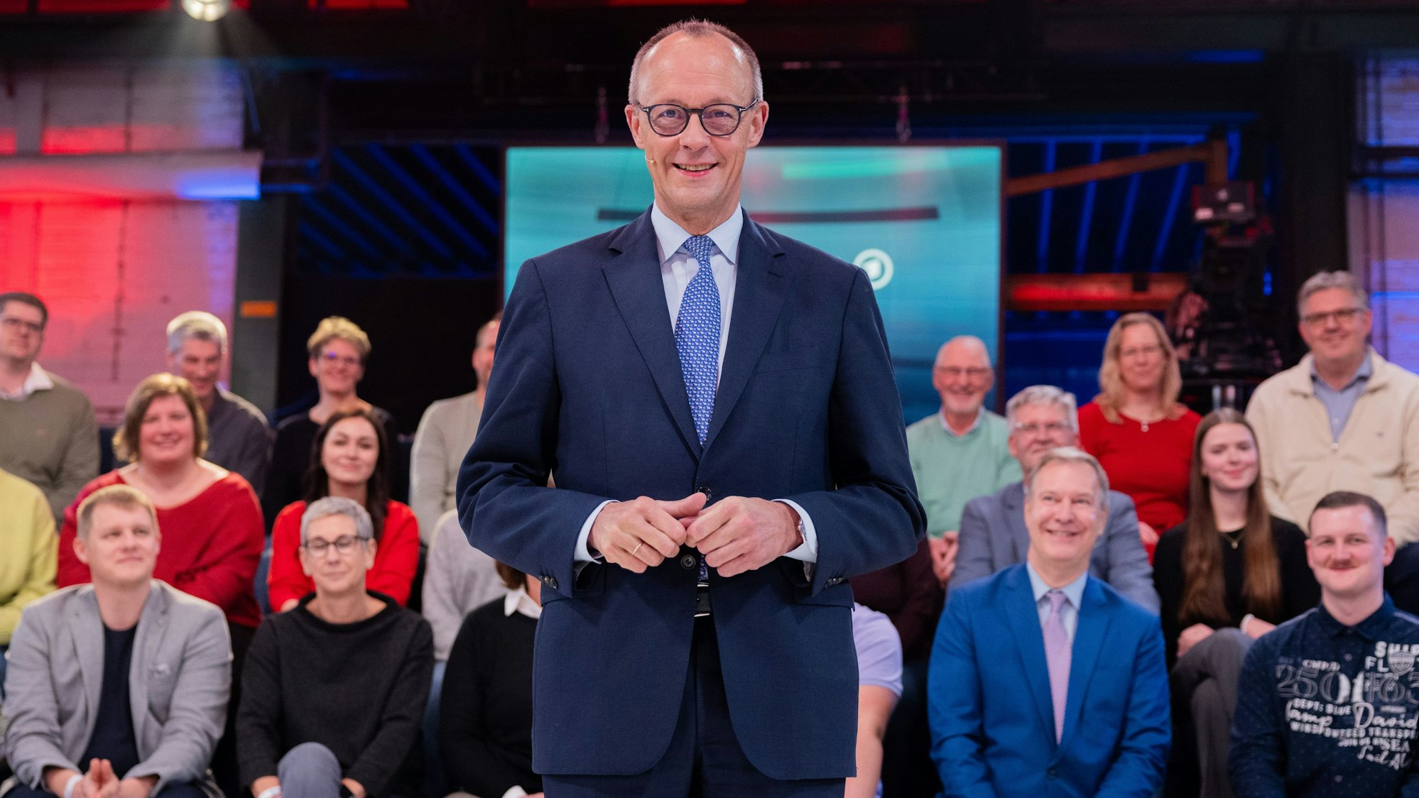 Friedrich Merz in der ARD-Sendung Arena, im Hintergrund Notfallsanitäter Hartmut Kreutz (vorderste Reihe, ganz links).