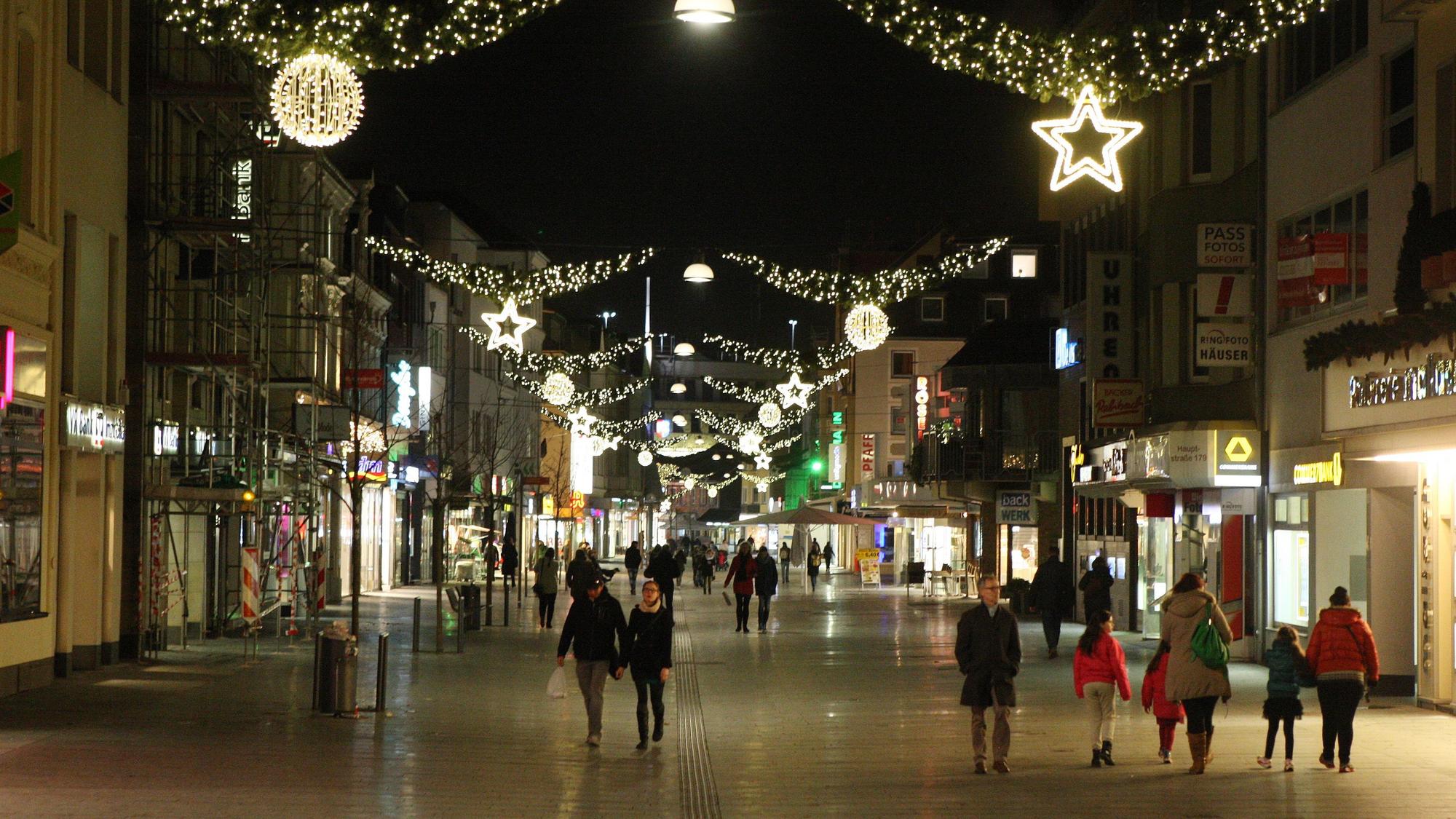 Menschen laufen durch die weihnachtlich geschmückte Bergisch Gladbacher Innenstadt.