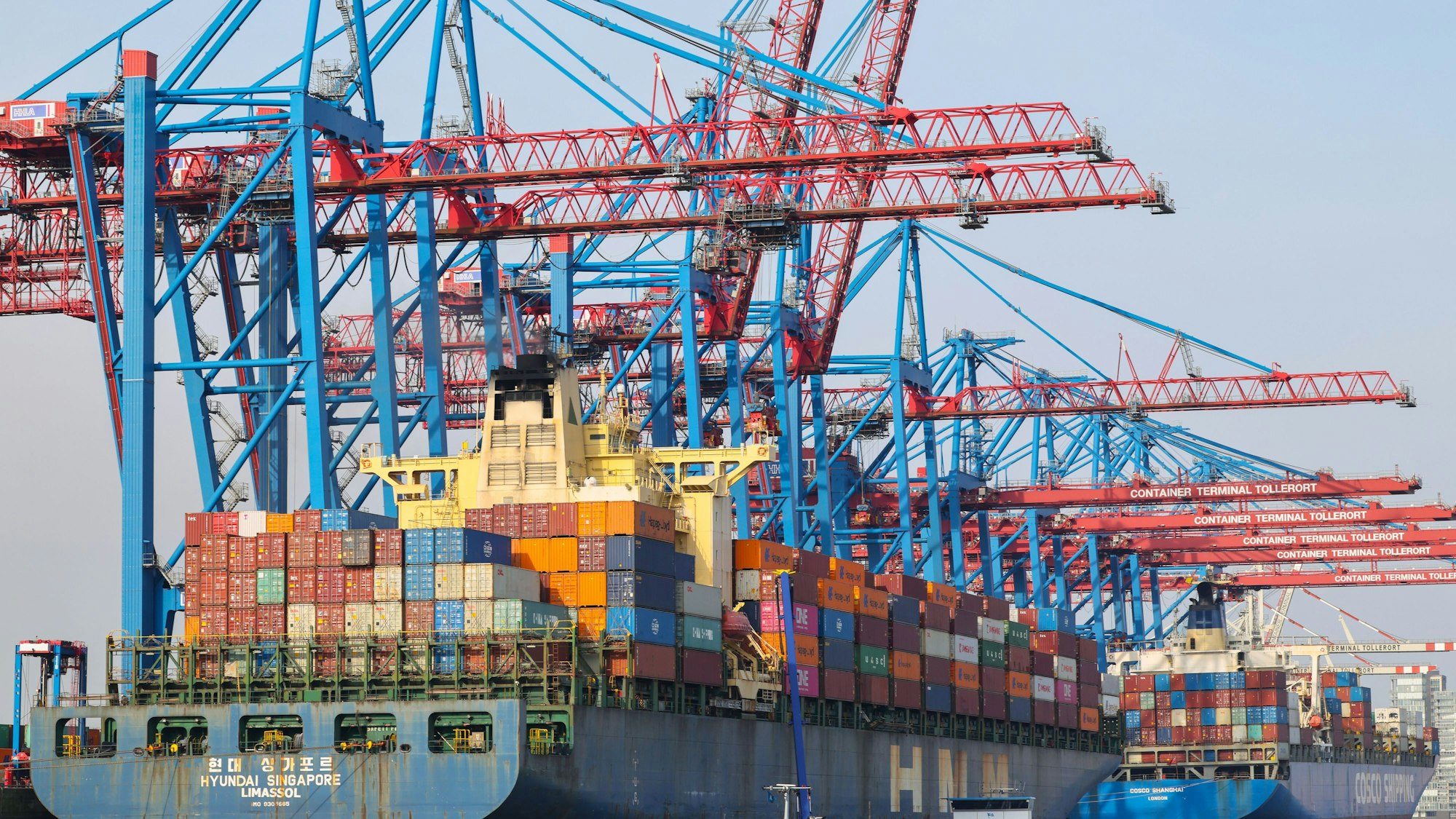 ARCHIV - 20.02.2025, Hamburg: Containerschiffe werden am Containerterminal Tollerort der Hamburger Hafen und Logistik AG HHLA be- und entladen.