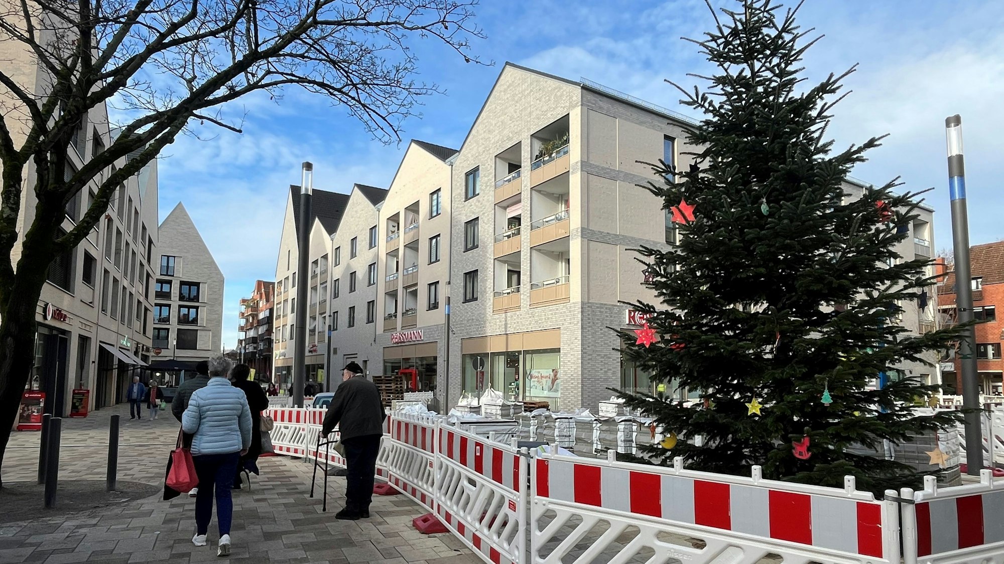 Noch ist der von Kindern geschmückte Weihnachtsbaum in der neuen Porzer City von Bauzäunen umrahmt, am Wochenende soll hier der Weihnachtsmarkt stattfinden.