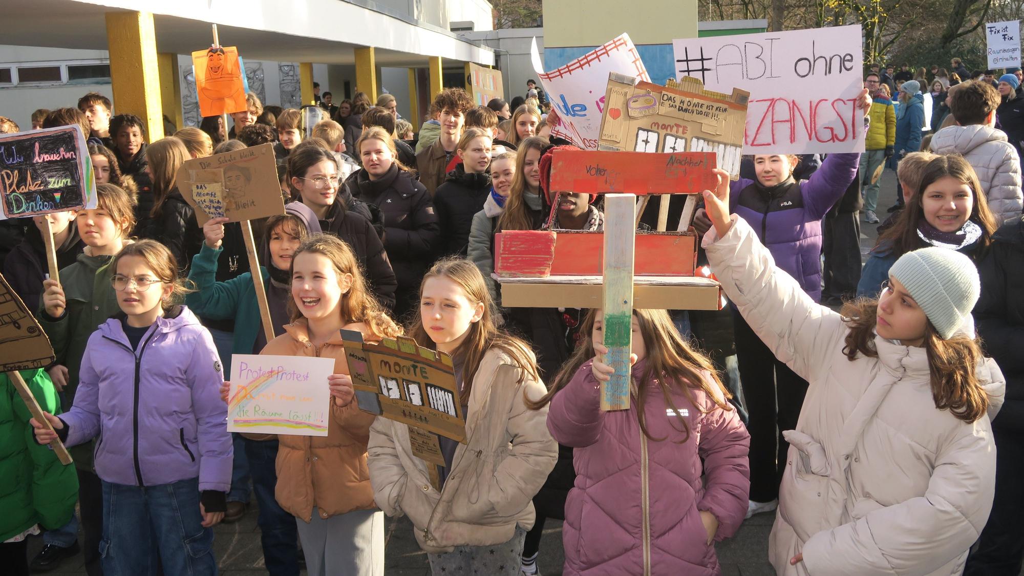 Kinder und Jugendliche halten selbstgeschriebene Protestplakate hoch.