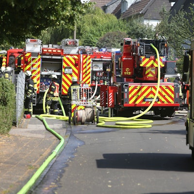 Mehrere Einsatzfahrzeuge der Feuerwehr stehen auf einer Straße.