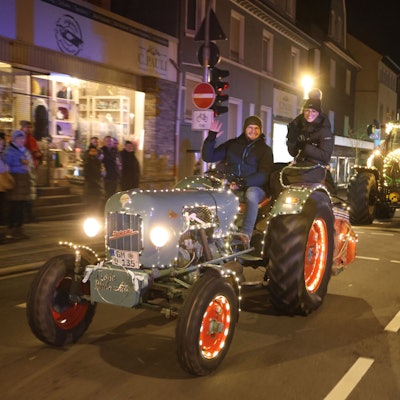 Zu sehen ist ein Konvoi weihnachtlich geschmückter Traktoren, die durch die Waldbröler Innenstadt fahren.