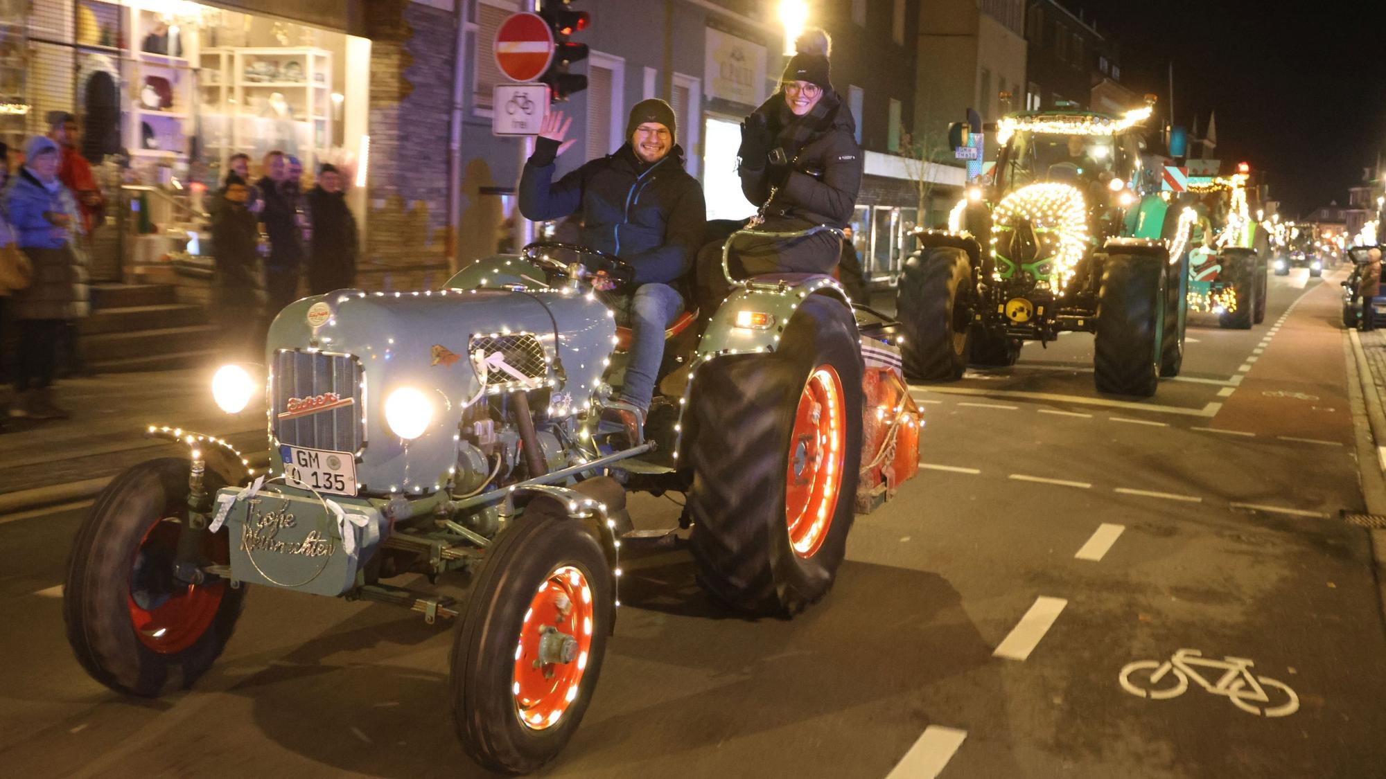 Zu sehen ist ein Konvoi weihnachtlich geschmückter Traktoren, die durch die Waldbröler Innenstadt fahren.
