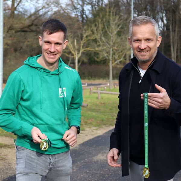Ralf Ulmer und Tobias Becker halten die Medaillen in die Höhe.