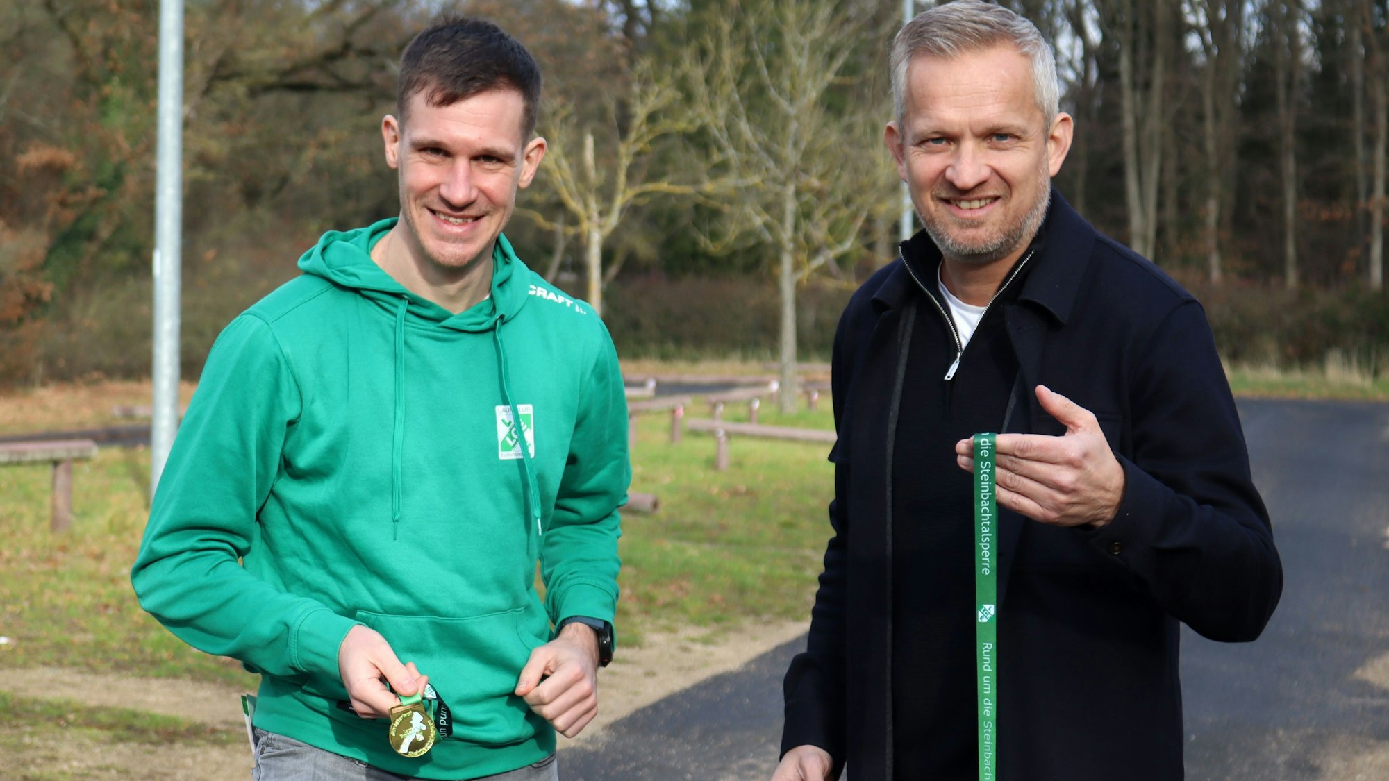 Ralf Ulmer und Tobias Becker halten die Medaillen in die Höhe.