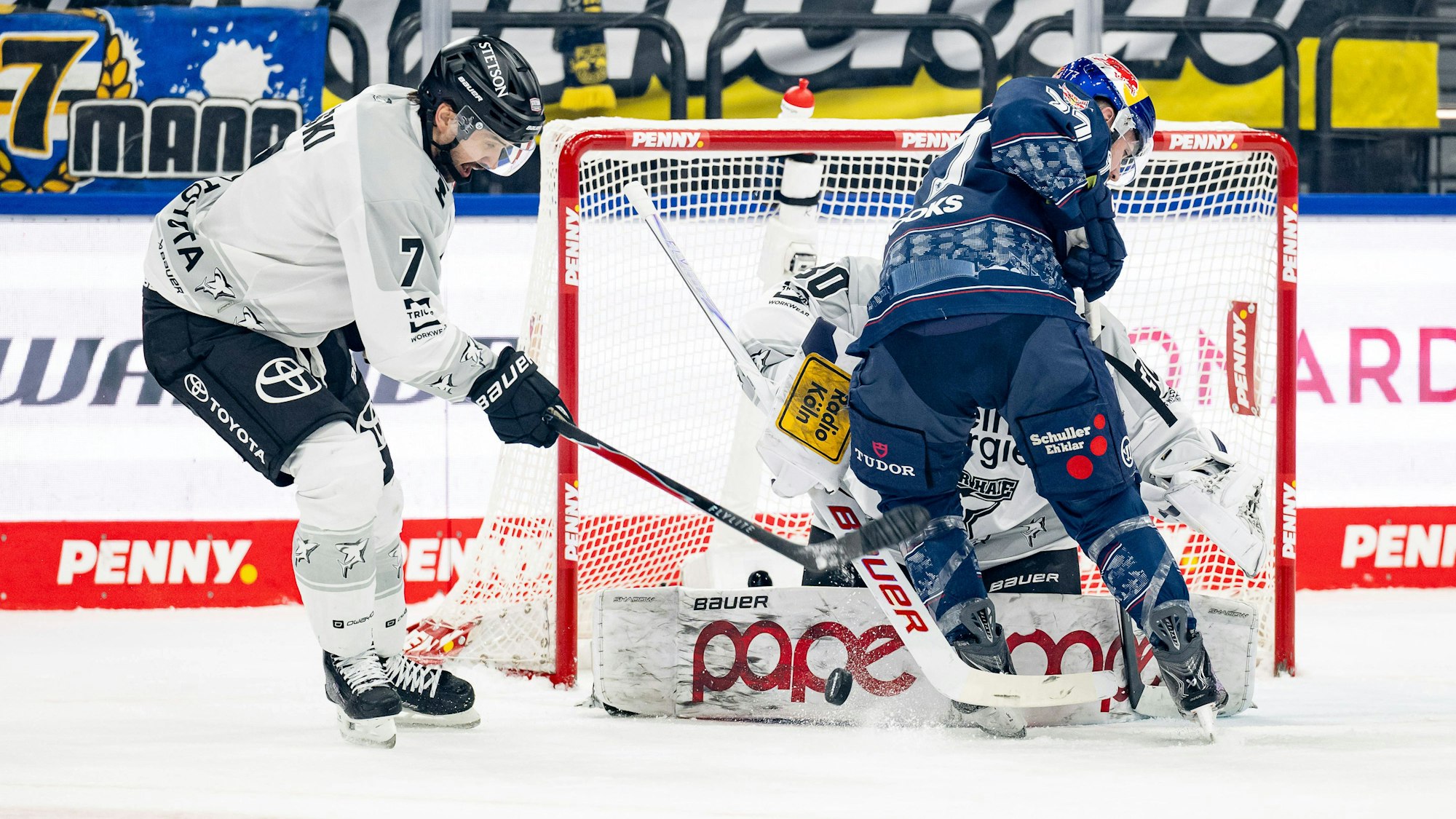 Münchens Adam Brooks beist sich an Oliwer Kaski (l.) und Haie-Goalie Janne Juvonen die Zähne aus.