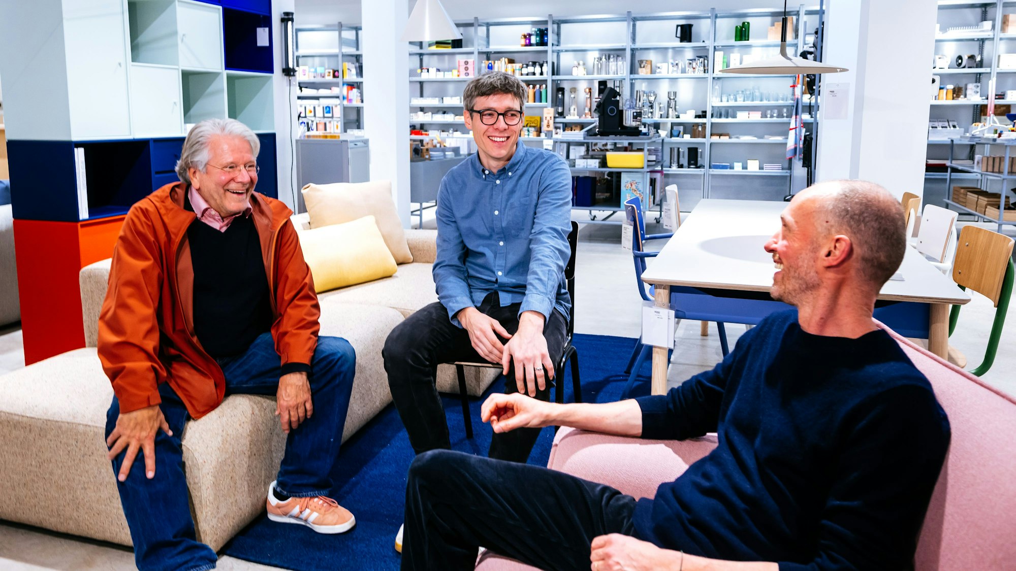 Zu sehen sind drei Männer im Gespräch.