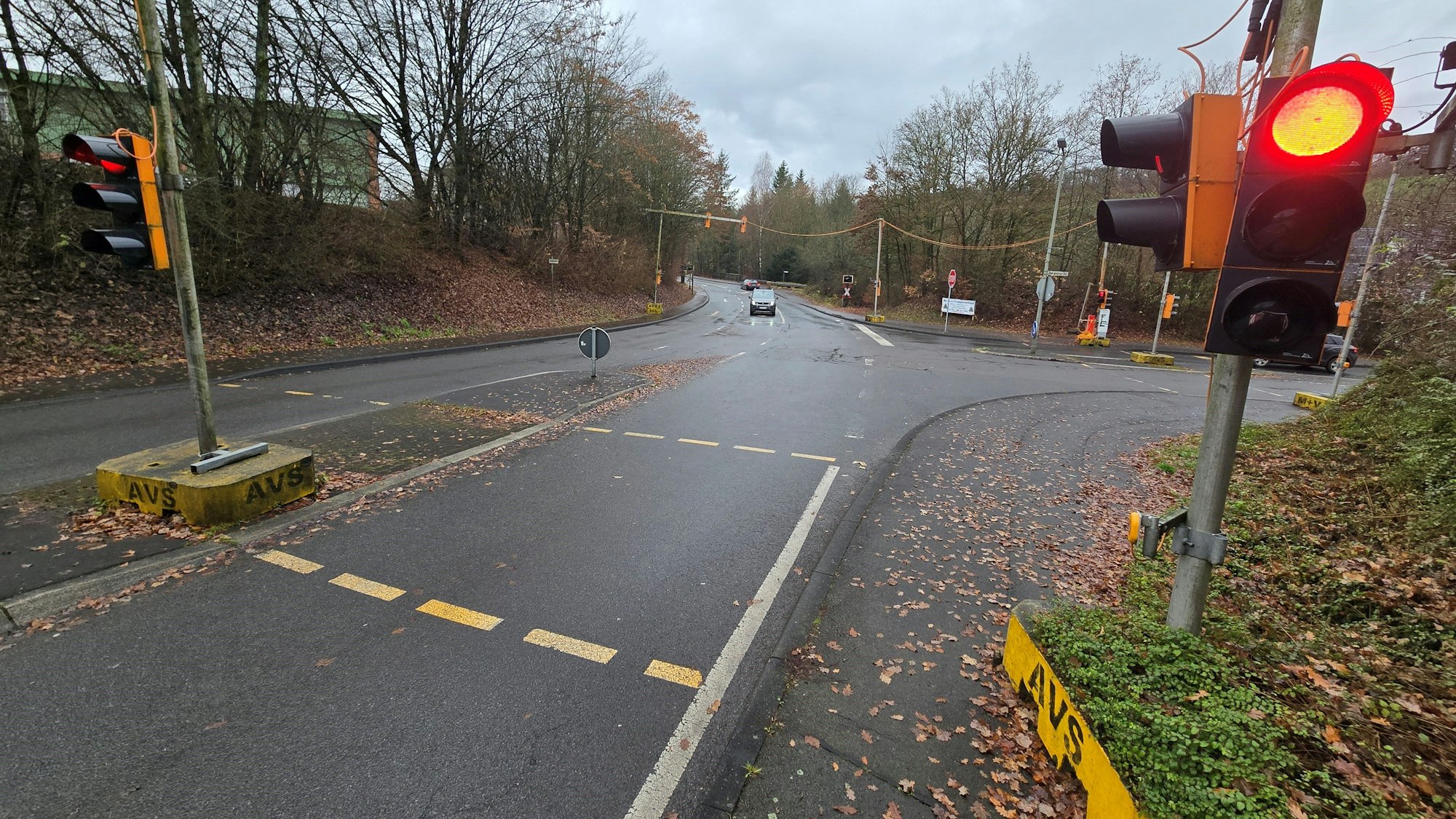 Eine rote Ampel, im Hintergrund eine leere Einmündung.