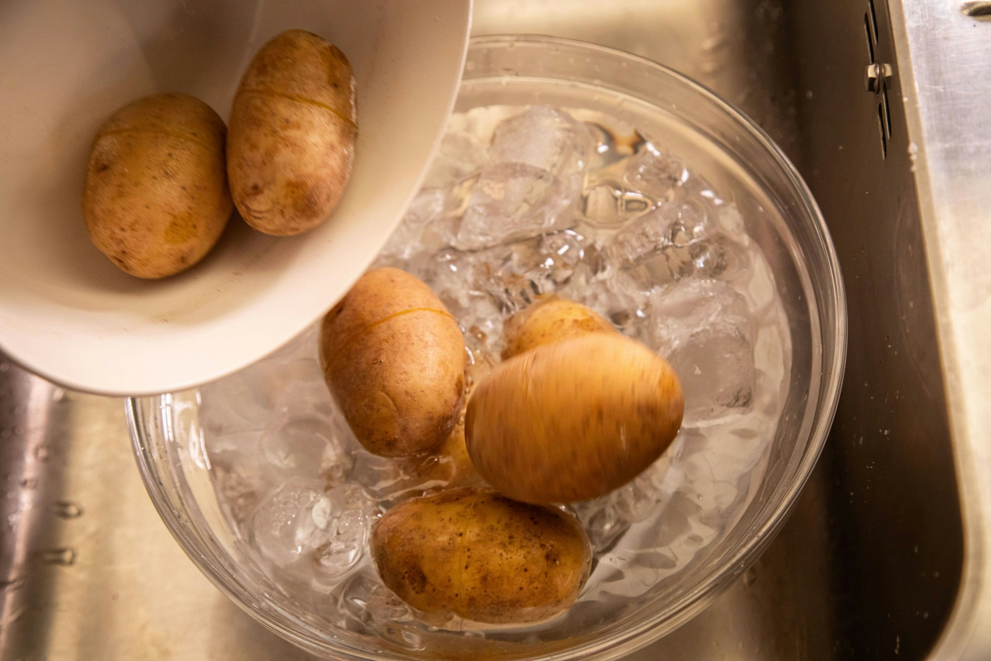 Schritt 3: Fertig gegarte Kartoffeln abgießen und im Eiswasser abschrecken.