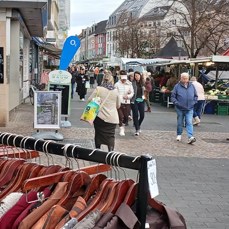Blick in die Siegburger Fußgängerzone, ein Kleiderständer im Vordergrund.