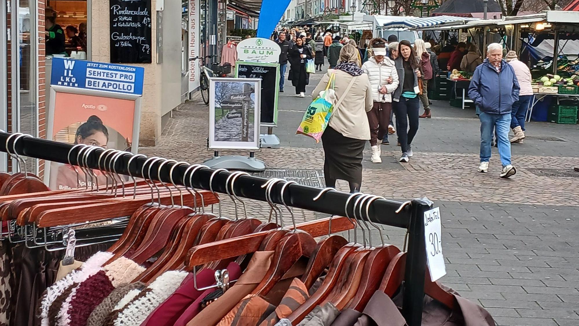 Blick in die Siegburger Fußgängerzone, ein Kleiderständer im Vordergrund.