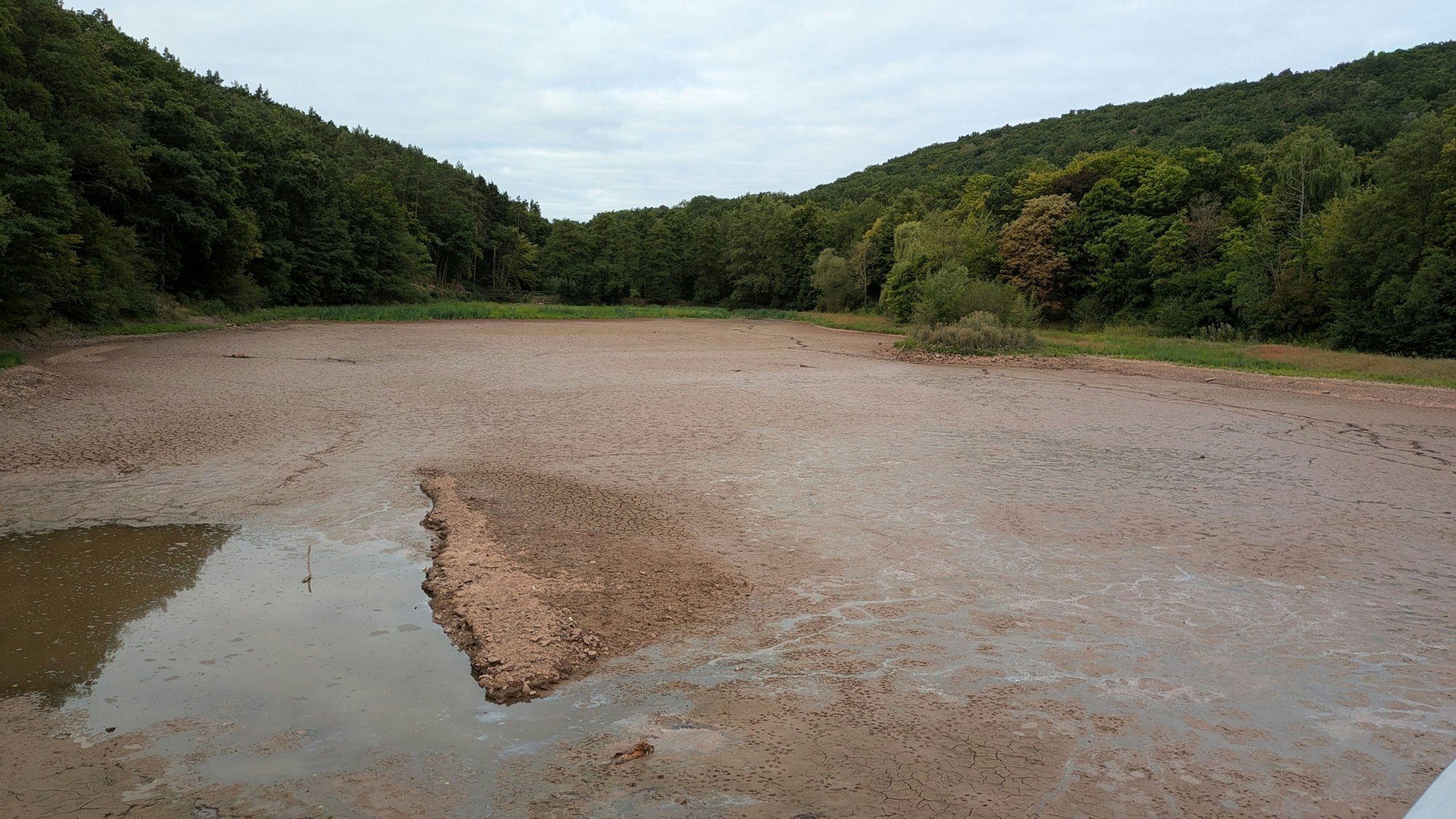 Das Wasser aus dem See ist abgeflossen, der Grund mit Schlamm bedeckt.