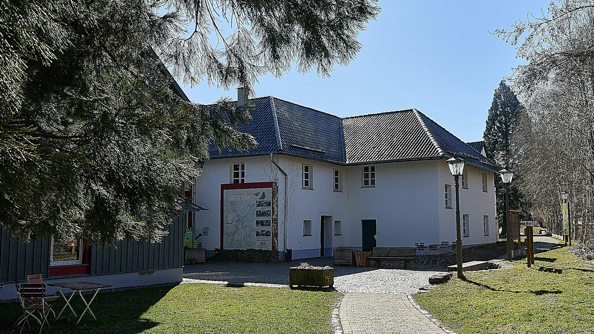 Das Bild zeigt Gebäude, die von Bäumen und Grünanlagen umgeben sind.