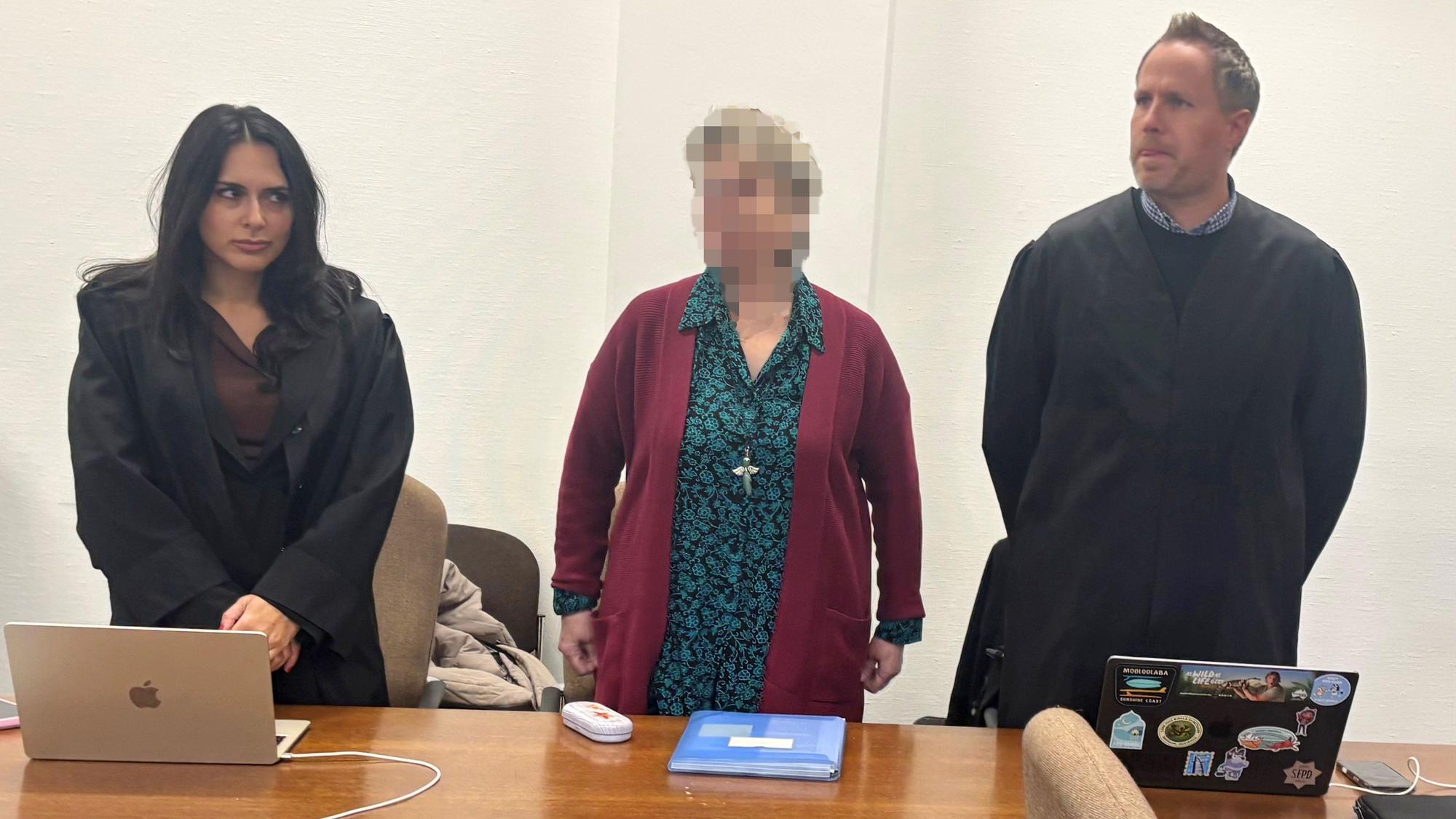 Eine 67-jährige Odenthalerin steht zwischen ihren Verteidigern vor dem Kölner Landgericht.