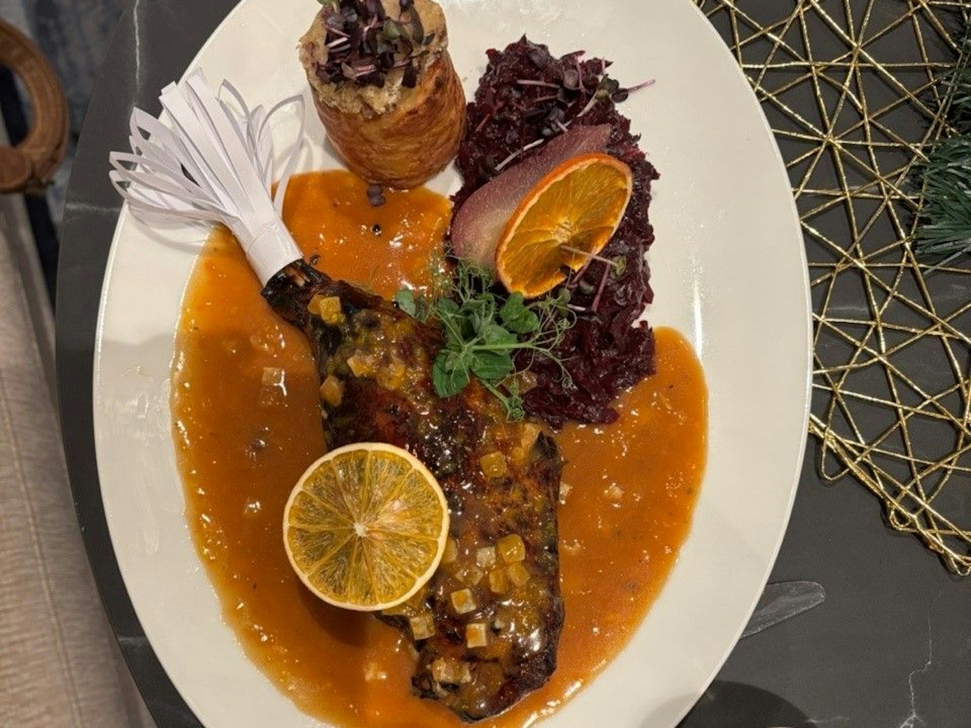 Zu sehen ist ein Gericht mit Gänsekeule auf einem Teller.