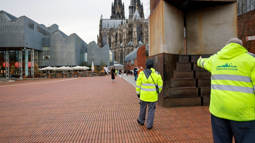 Wachleute der städtischen Firma KGAB bewachen den Heinrich-Böll-Platz.