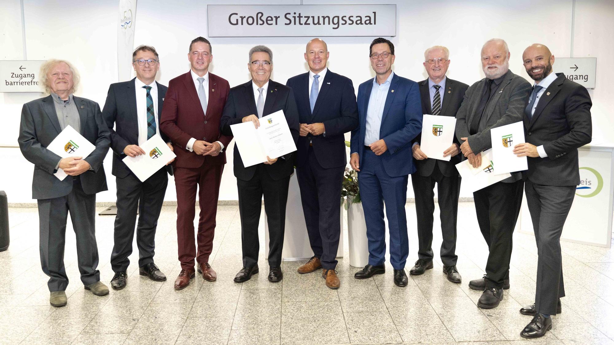 Zu sehen ist eine Gruppe von Männern mit Urkunden.