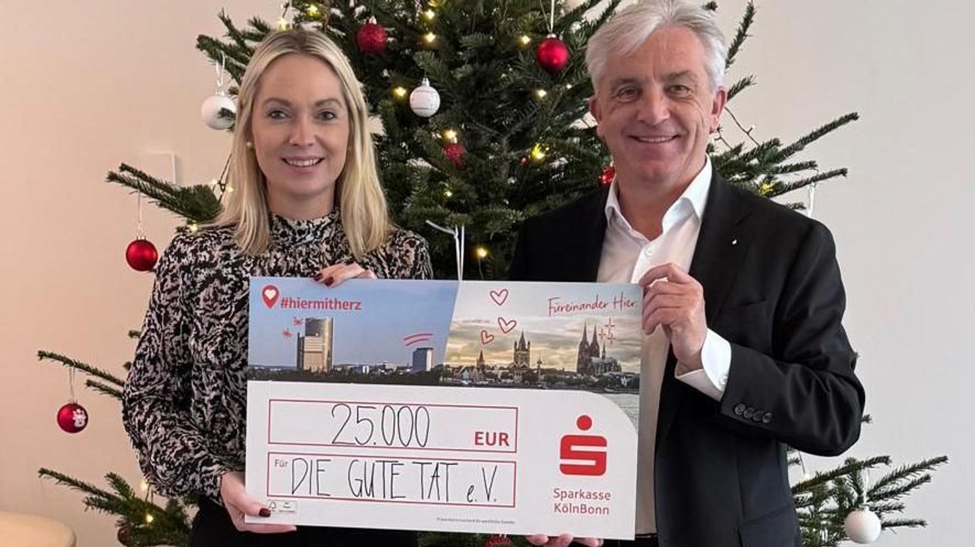 Rainer Virnich vom Vorstand der Sparkasse Köln Bonn überreicht Julia Heinen, Vorsitzende der Rundschau-Altenhilfe, einen symbolischen Spendenscheck über 25000 Euro.
