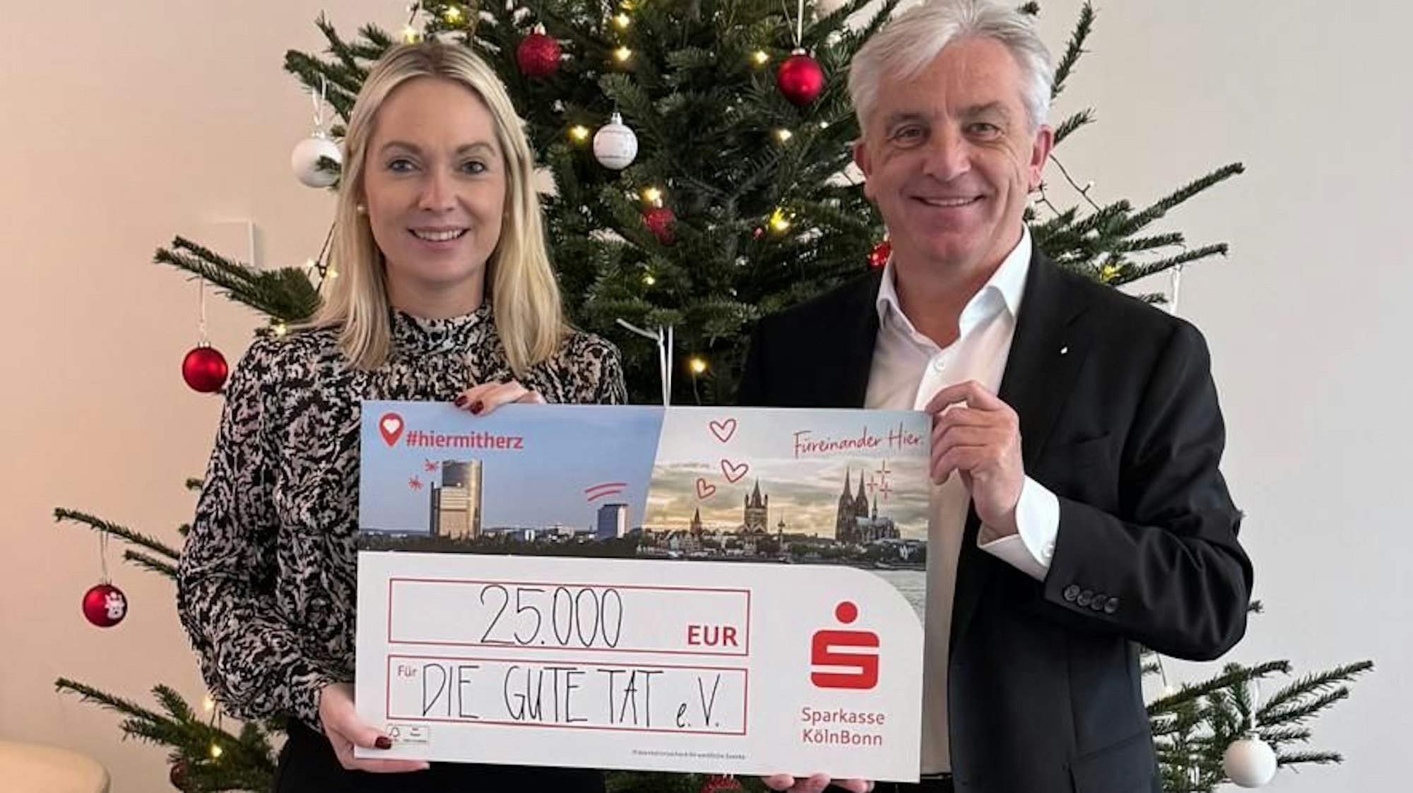 Rainer Virnich vom Vorstand der Sparkasse Köln Bonn überreicht Julia Heinen, Vorsitzende der Rundschau-Altenhilfe, einen symbolischen Spendenscheck über 25000 Euro.