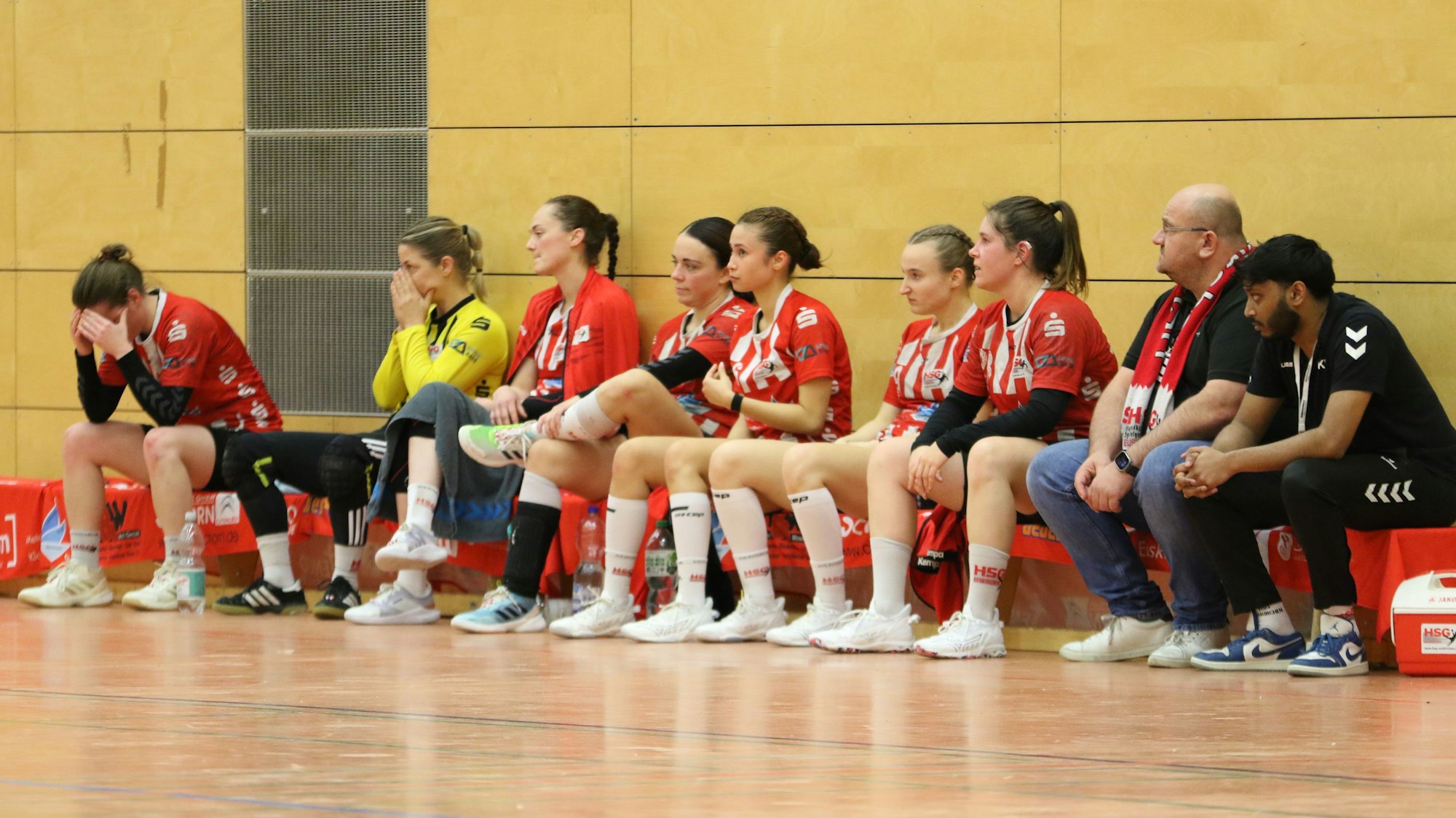 Blick auf die Ersatzbank. Eine Spielerin vergräbt den Kopf in den Händen, eine weitere hat die Hände vorm Gesicht zusammengeschlagen.
