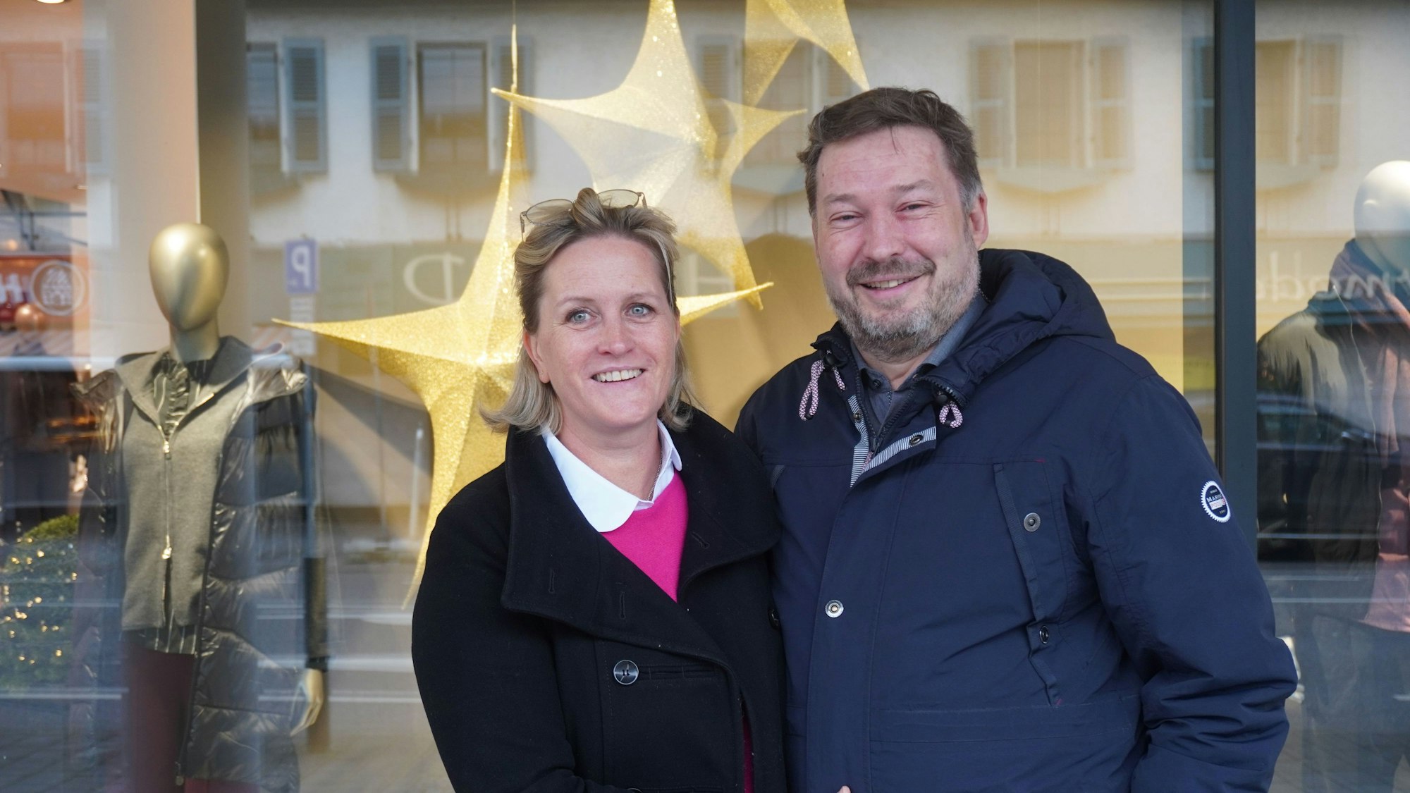 Das Foto zeigt das Paar vor dem Schaufenster eines Geschäfts.