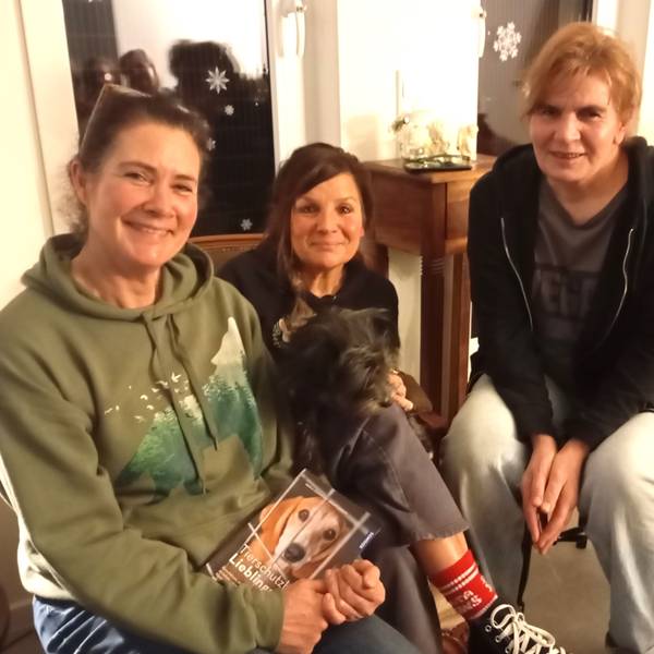 Das Foto zeigt die drei Frauen, eine mit einem Hund auf dem Schoß.