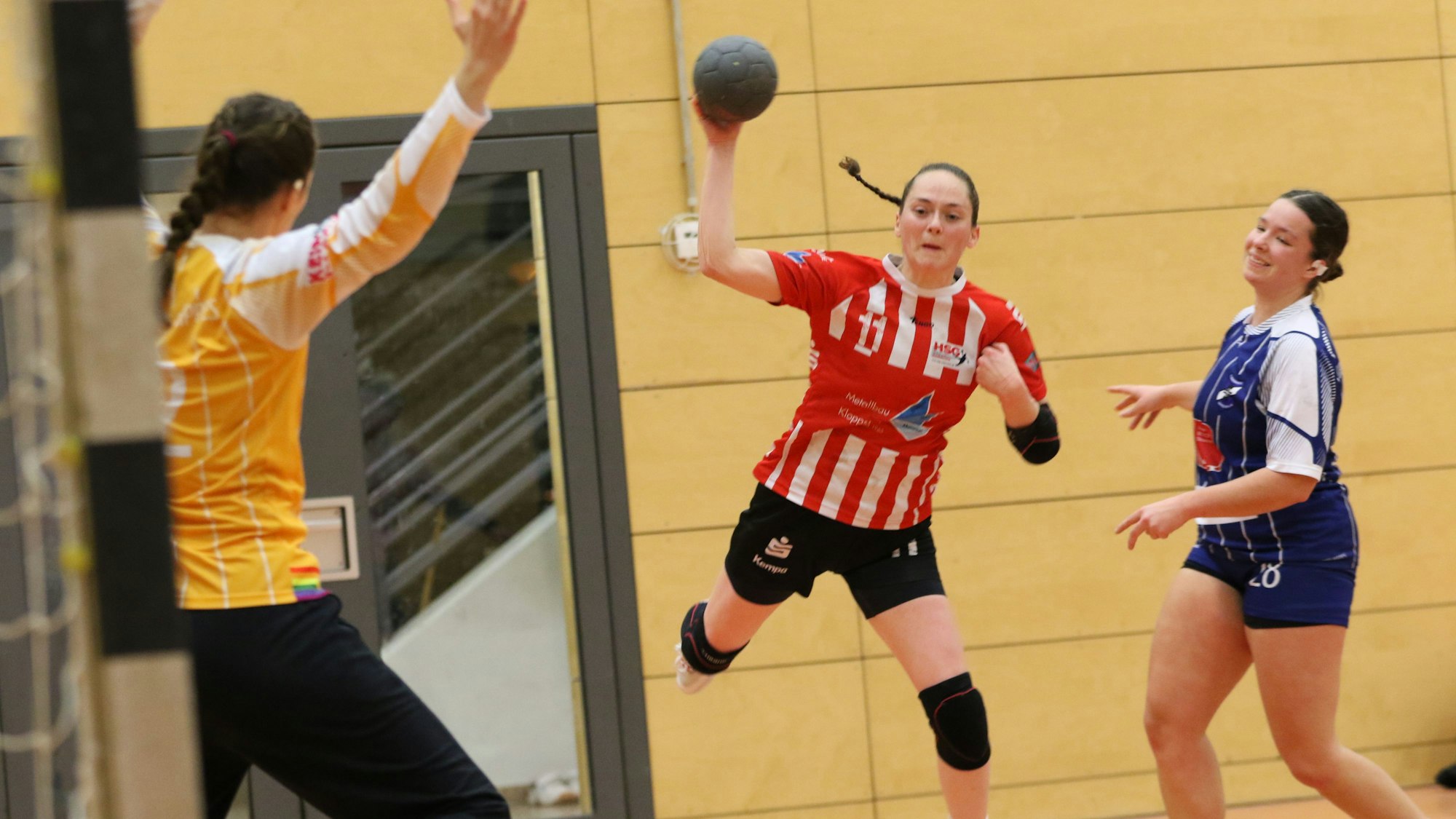 Ulrike Schmidt-Gogo wirft, die Torwart steht ihr gegenüber. Ihre Gegenspielerin lacht.