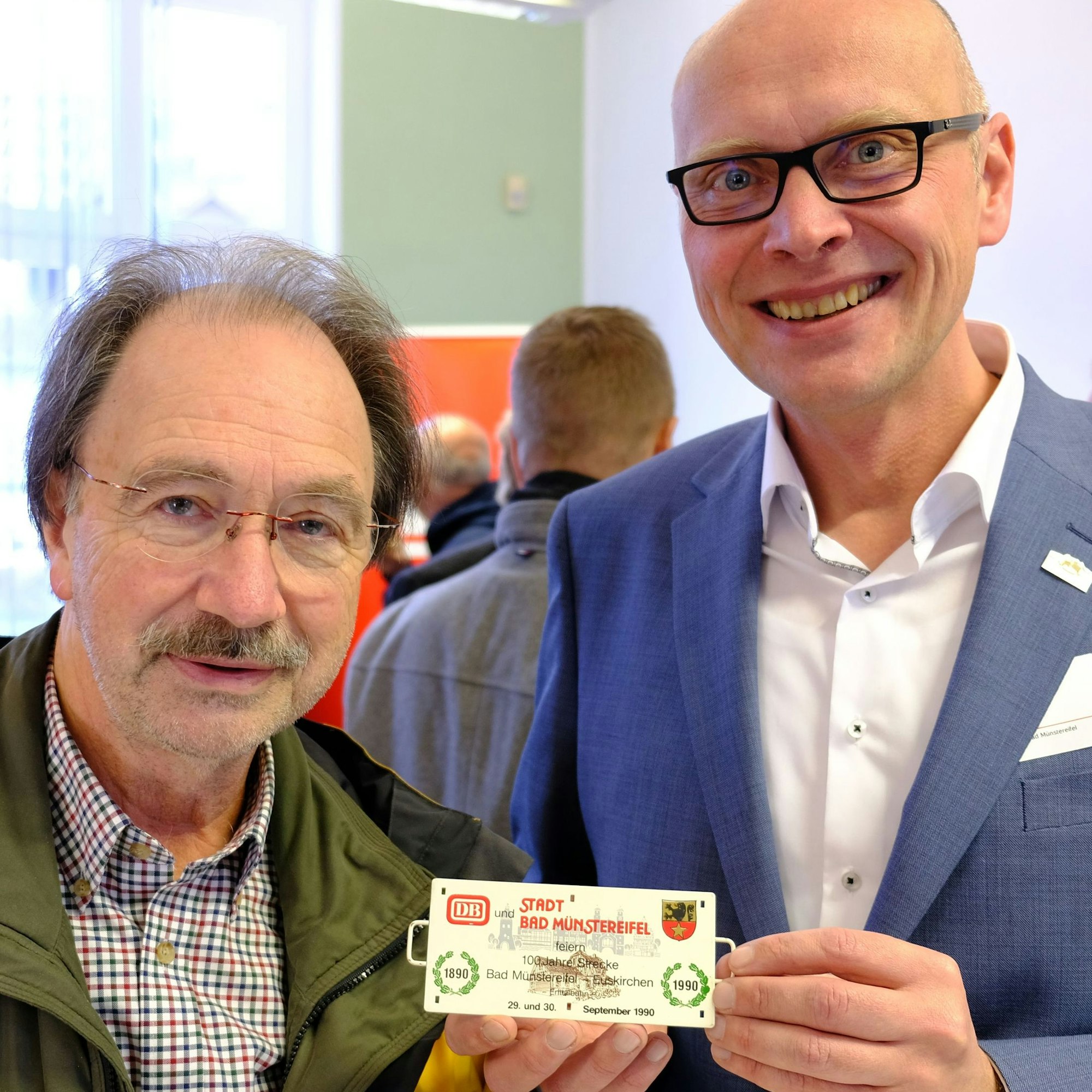 Bürgermeister Sebastian Glatzel (r.) präsentiert ein Miniaturschild, das er von Matthias Hürten erhalten hat.