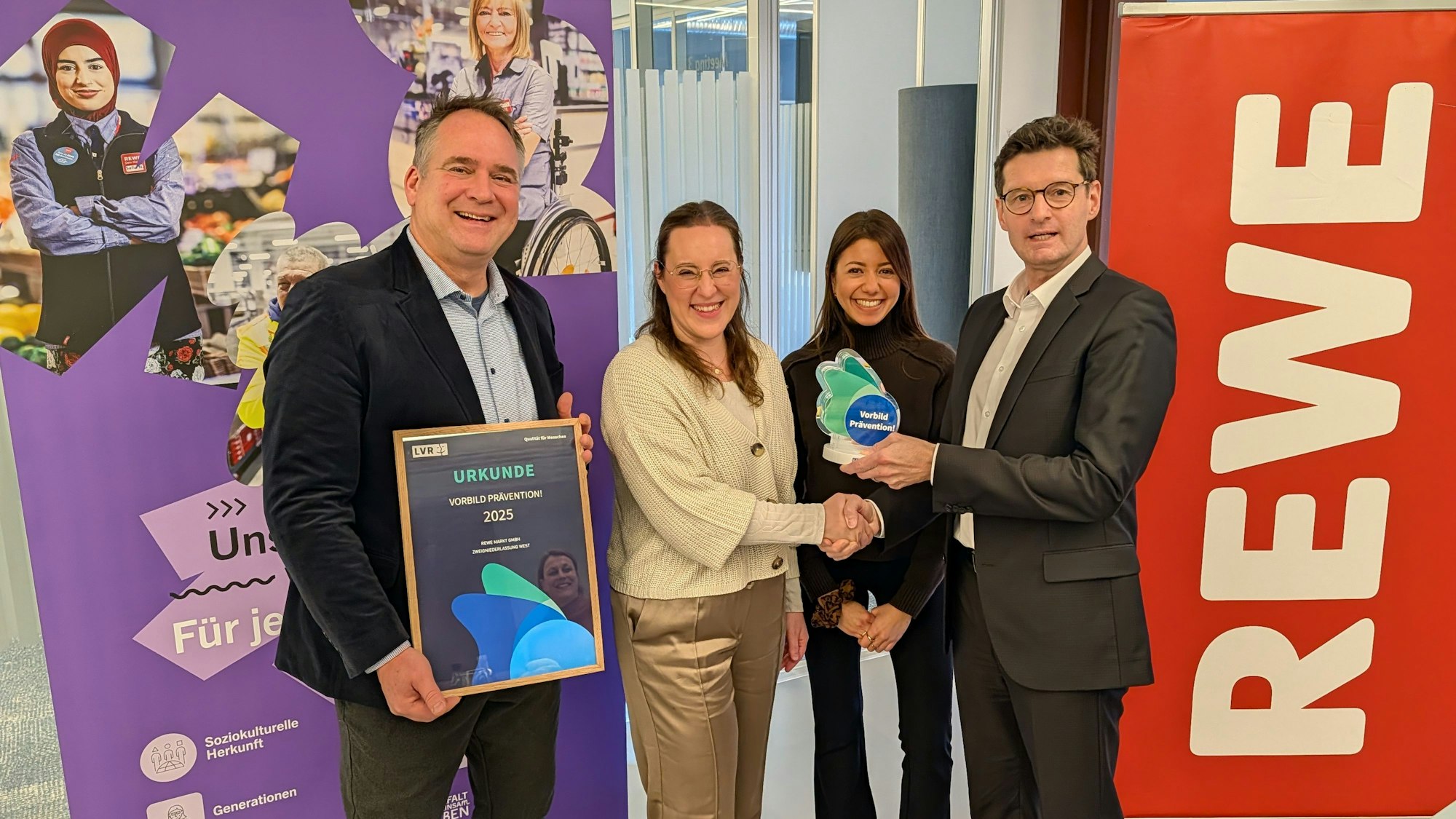 Das Foto zeigt die Verleihung von Preis und Urkunde in der Zentale von Rewe West in Hürth.