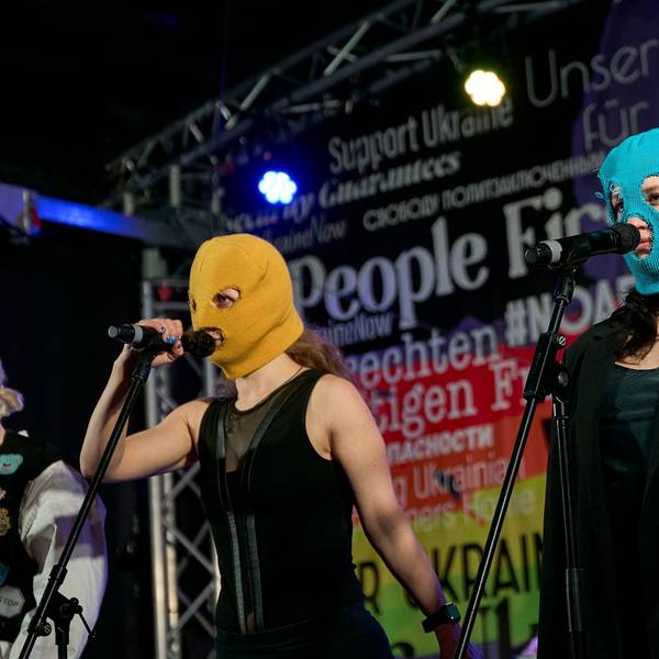Beim Konzert der Band Pussy Riot gegen den Krieg in der Ukraine am Brandenburger Tor in Berlin stehen Bandmitglieder mit Stoffmasken auf der Bühne.